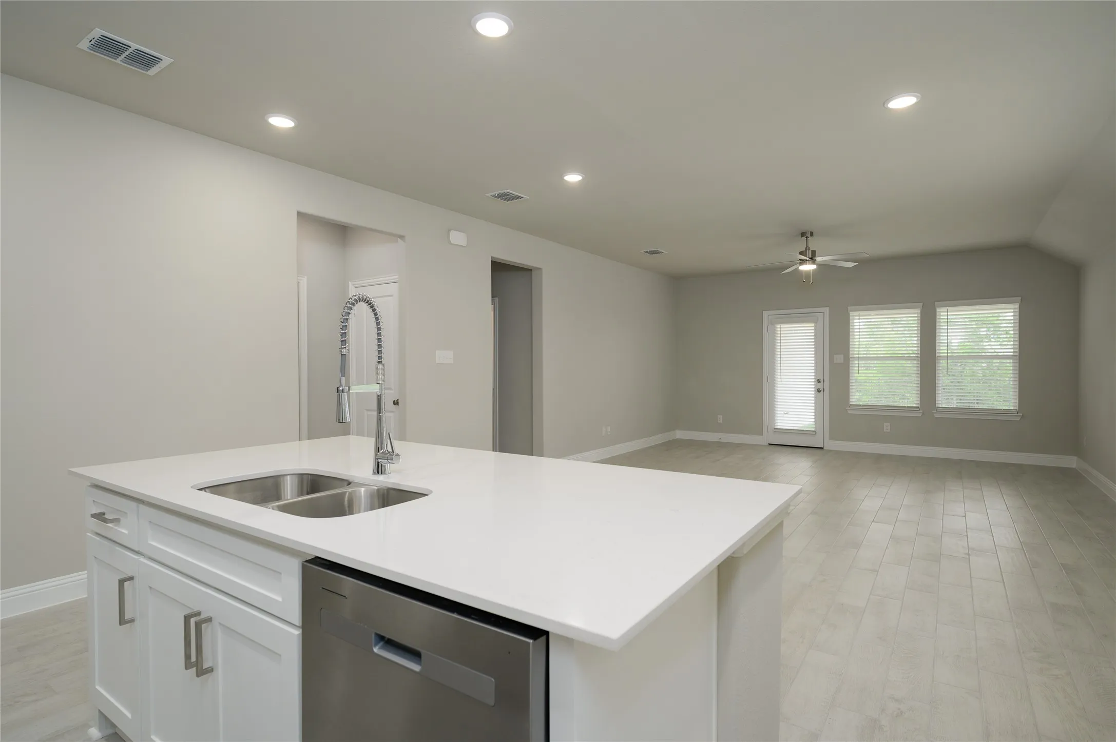 Kitchen with a sink, visible vents, baseboards, dishwasher, and a ceiling fan