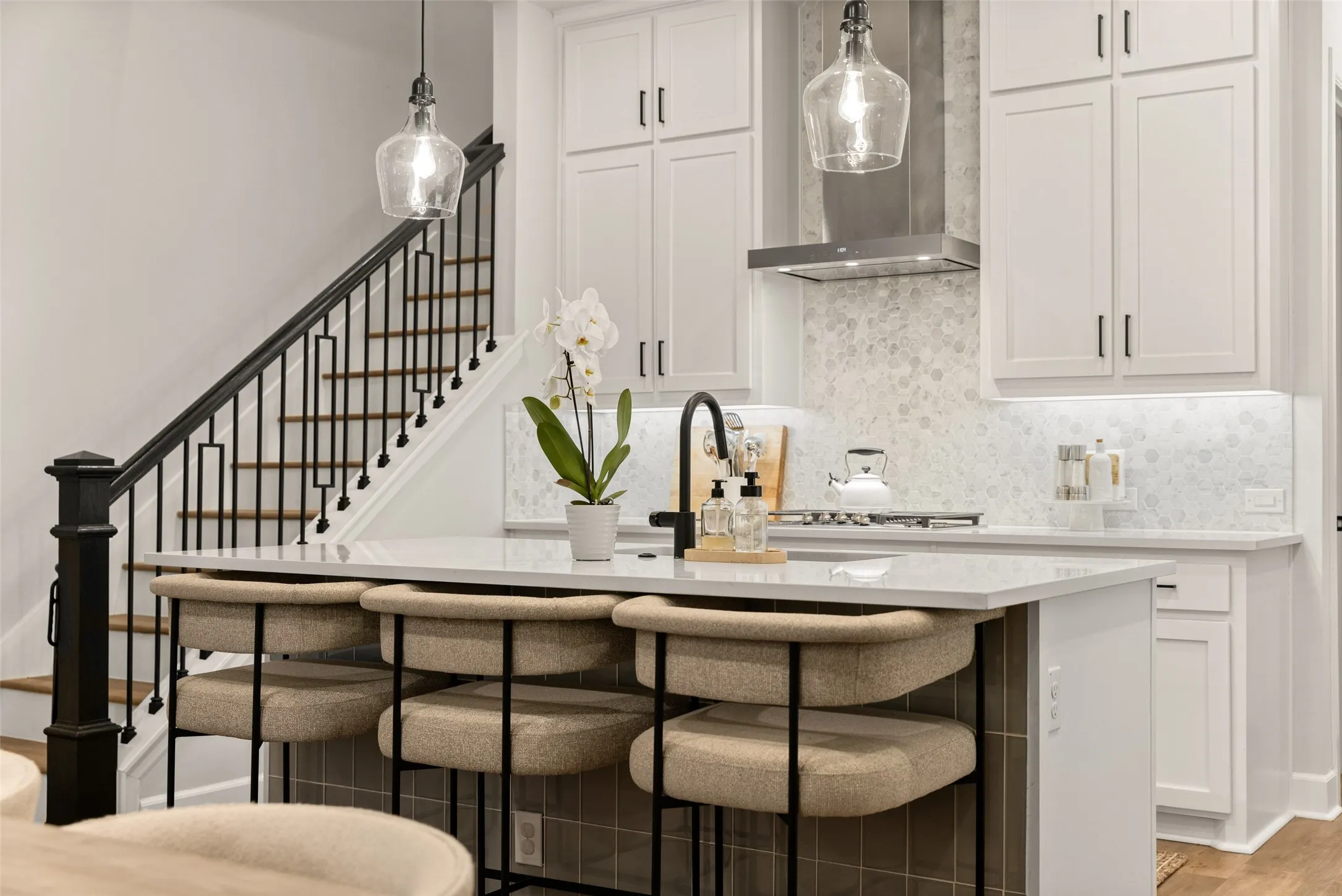 The kitchen serves as the social center of the home, where quartz countertops and custom shaker cabinetry create a space that is as beautiful as it is practical