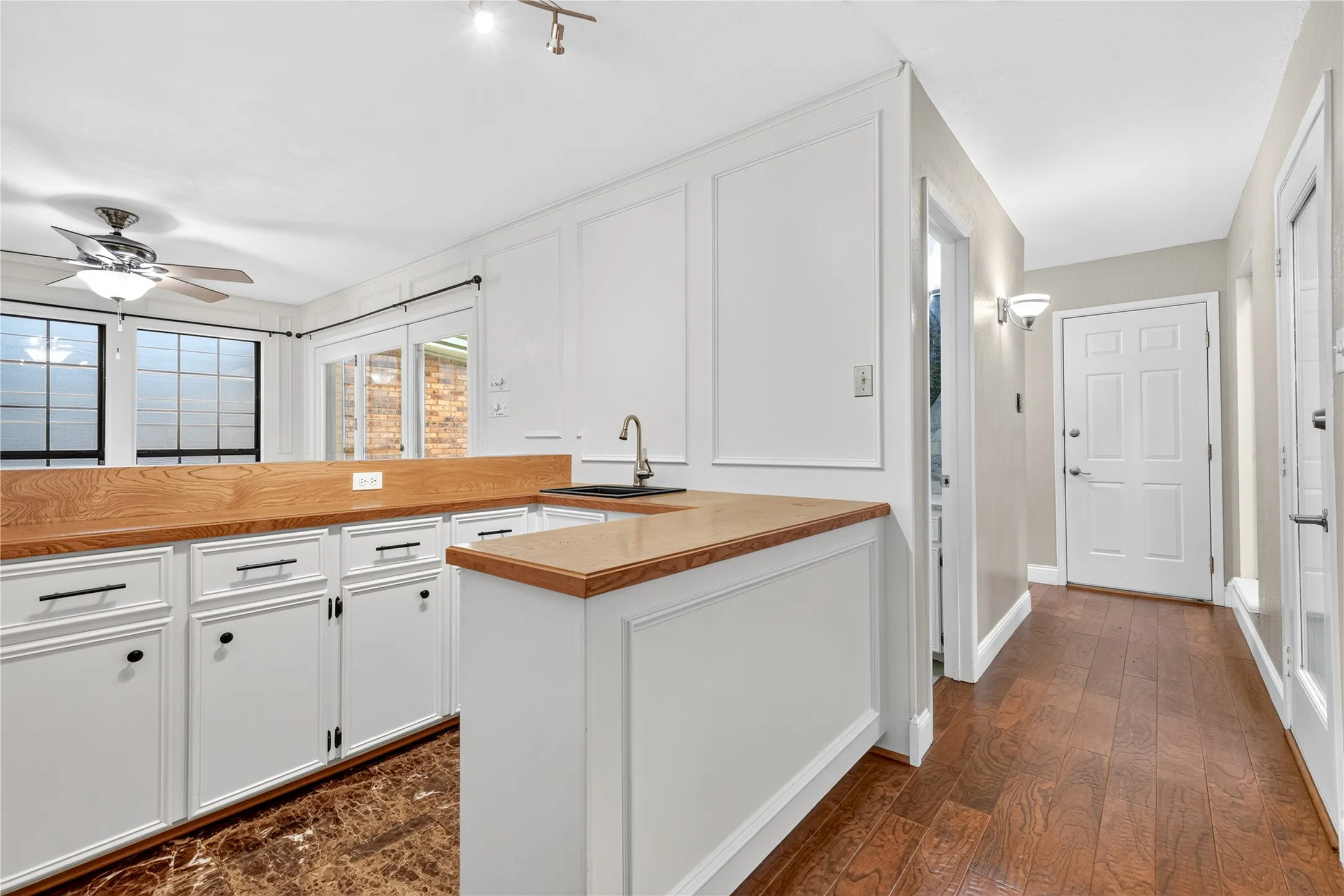 Wet bar is across from the atrium windows giving natural light as well as the sitting room windows and doors.  Half bath is conveniently located off hallway.