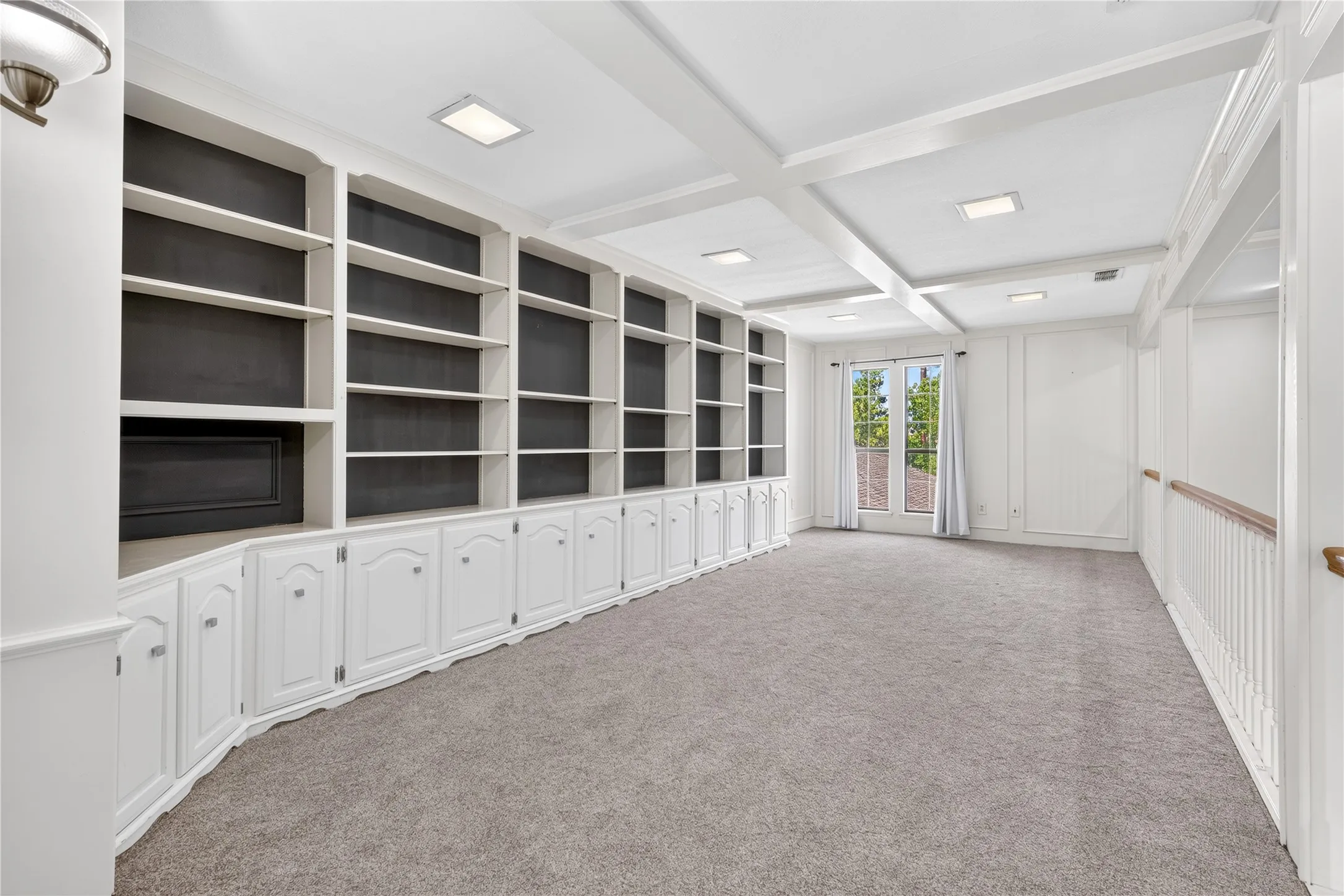 Wall of built ins and windows overlooking the back yard.