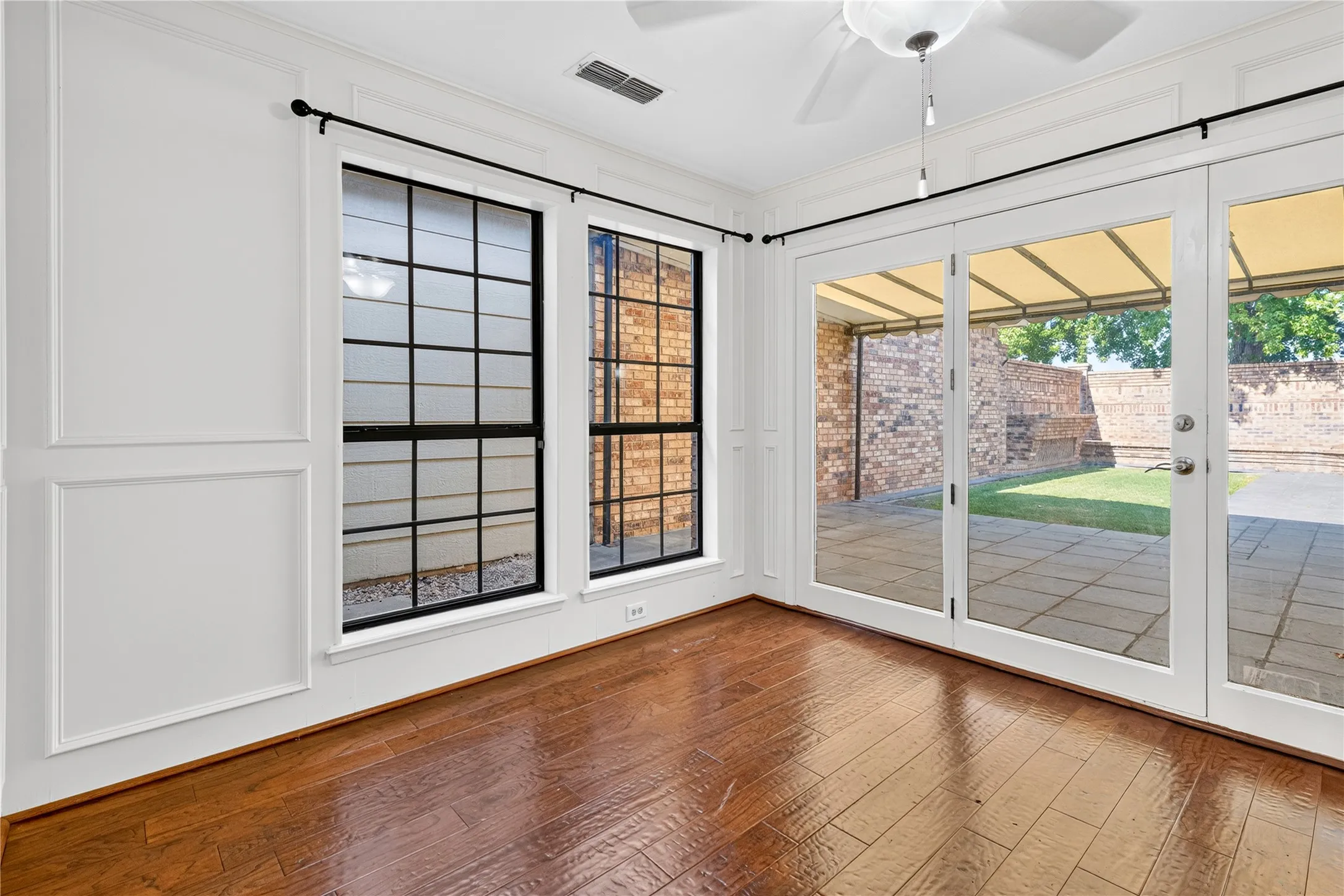 This sitting area boasts double windows along with glass door and side lights overlooking the covered canopy area in the back yard.