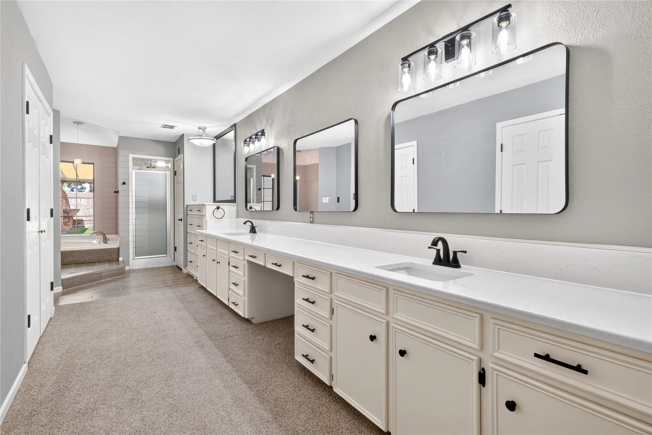 Long bathroom vanity with double undermount sinks and updated fixtures, stylish mirrors and lighting.  So much space!!!