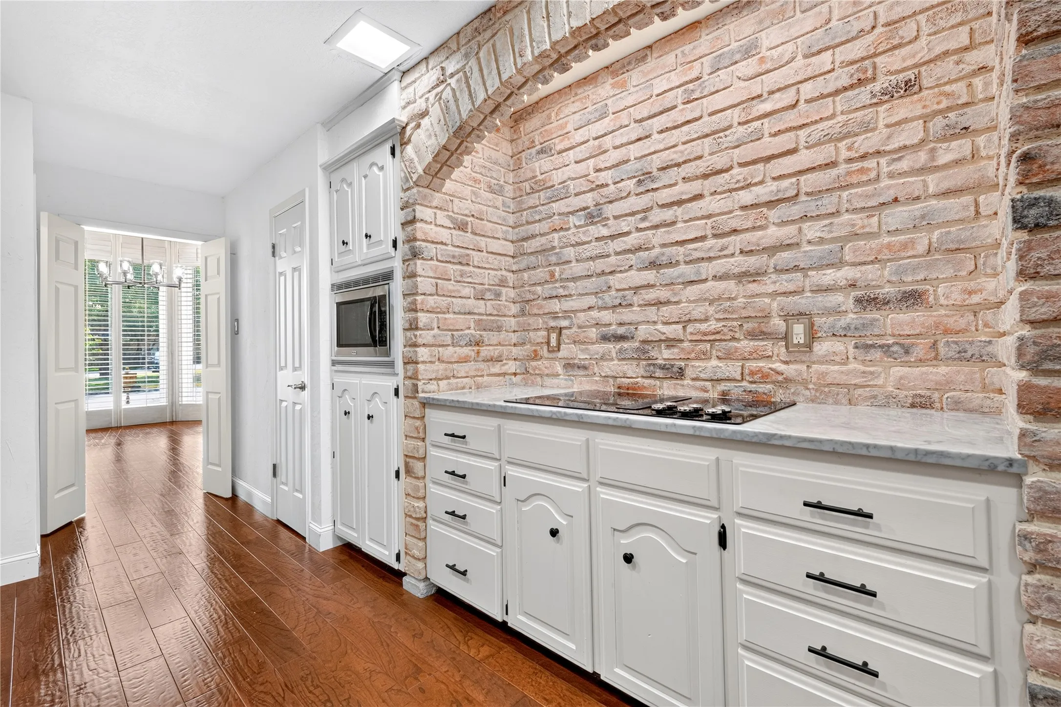 Arched brick with bright lighting over the cooktop space.
