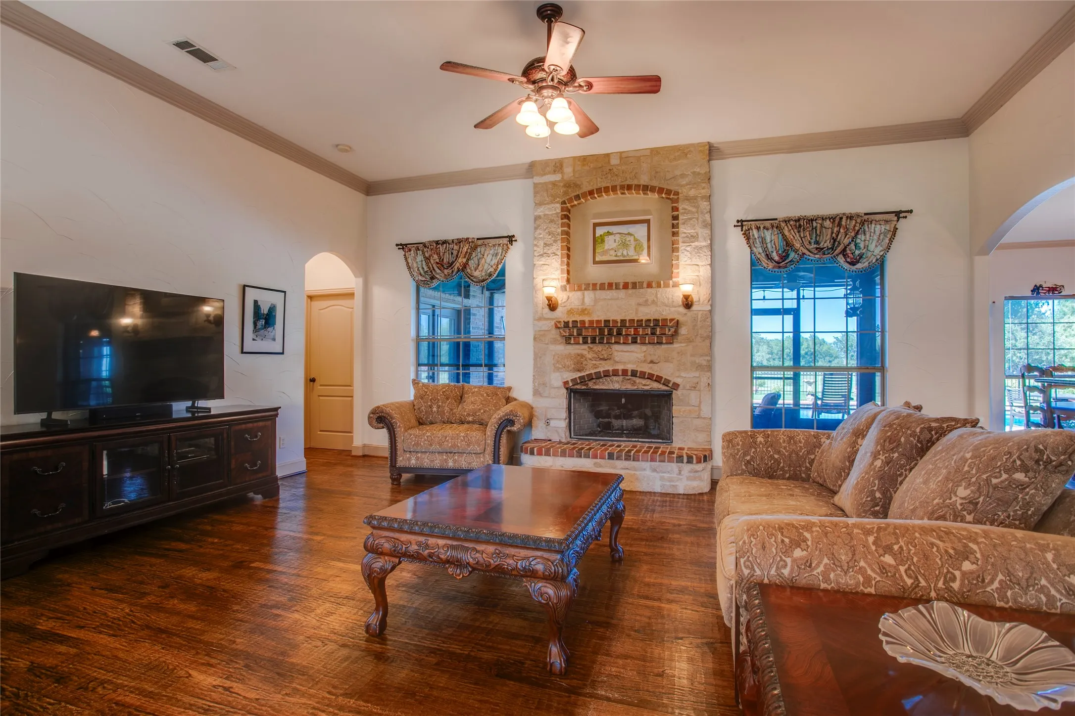 Large living area with solid oak hardwood flooring and stone fireplace