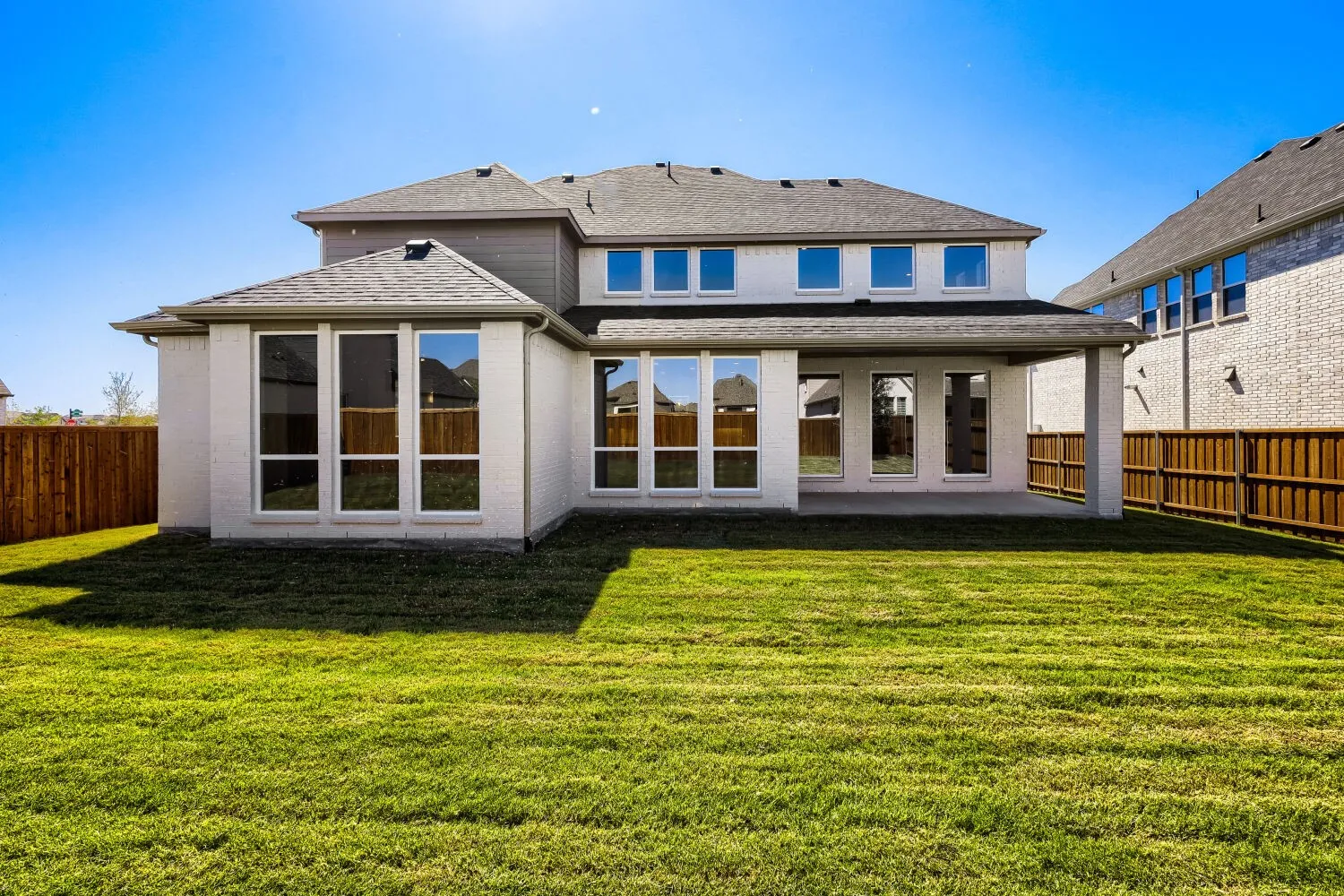 Expansive green lawn with a wood privacy fence
