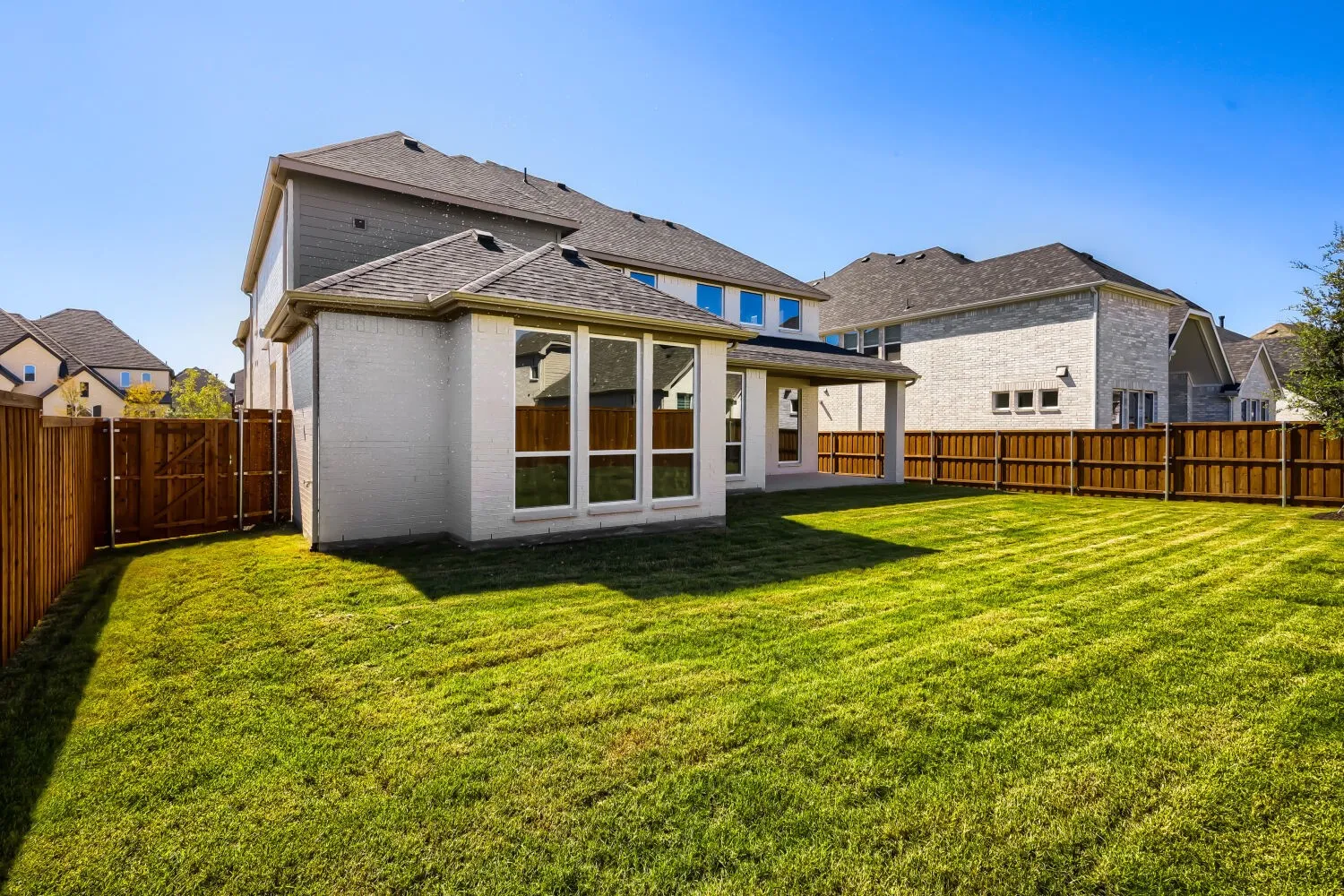 Expansive green lawn with a full wooden privacy fence
