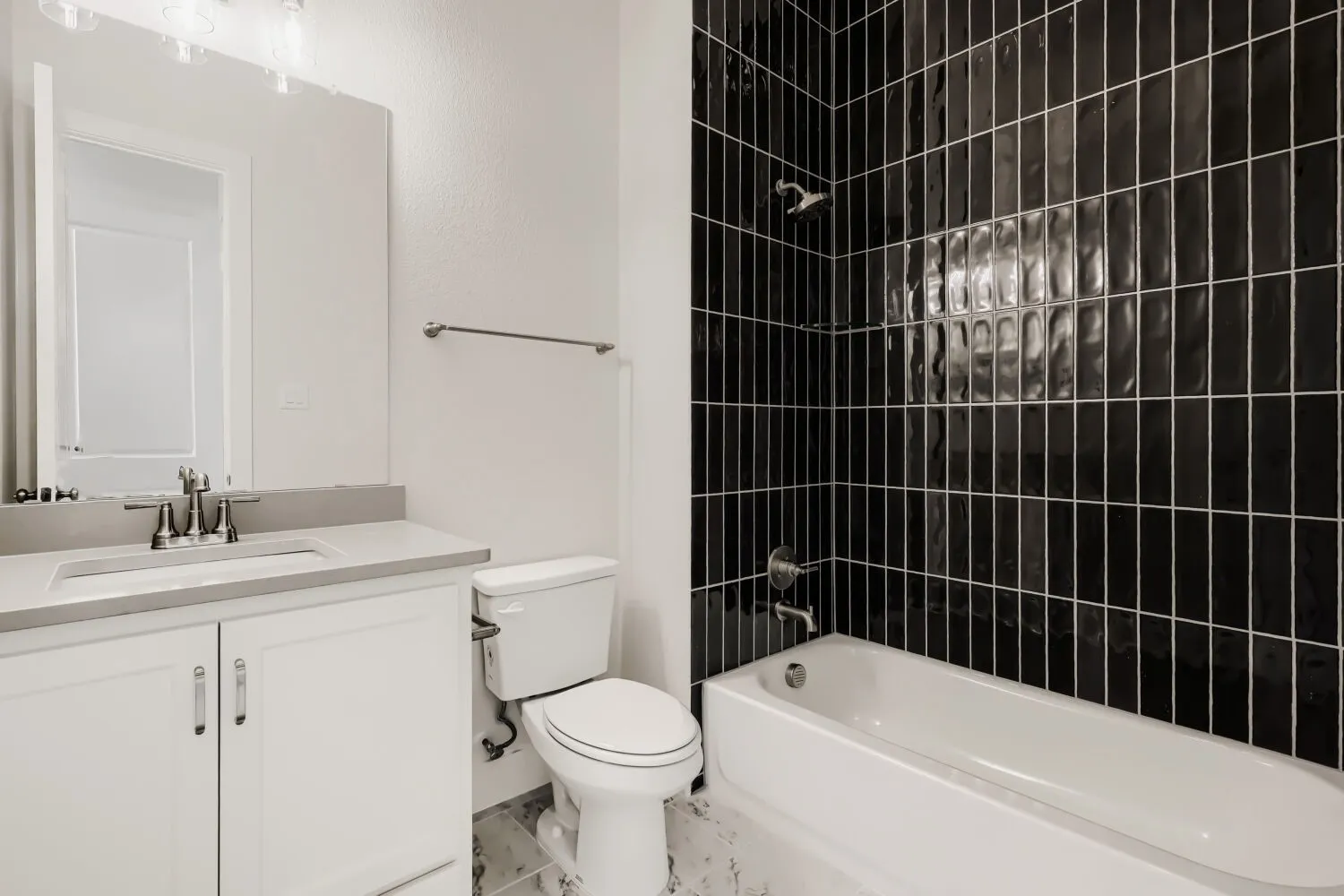Sleek bathroom featuring a vanity with a light-toned countertop, a rectangular undermount sink, and a large mirror