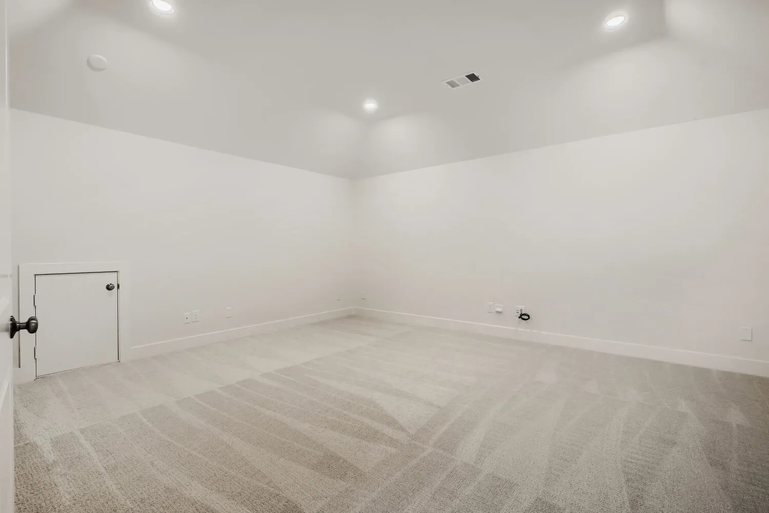 Recessed lighting, sloped ceiling, light-toned carpeting, and white trim