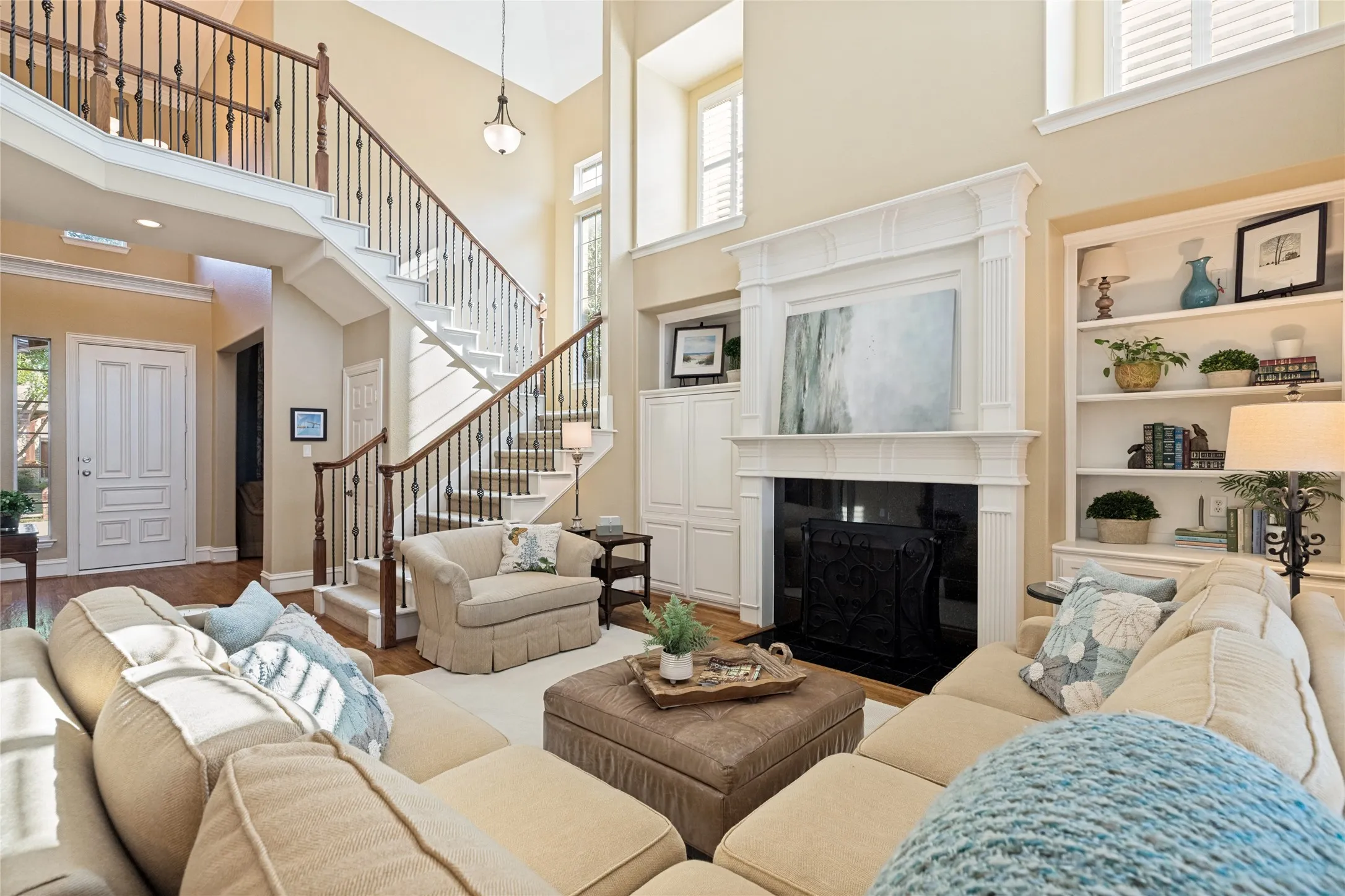 Spacious living area downstairs with gas fireplace, double stacked mantel, built-in bookcases and cabinetry