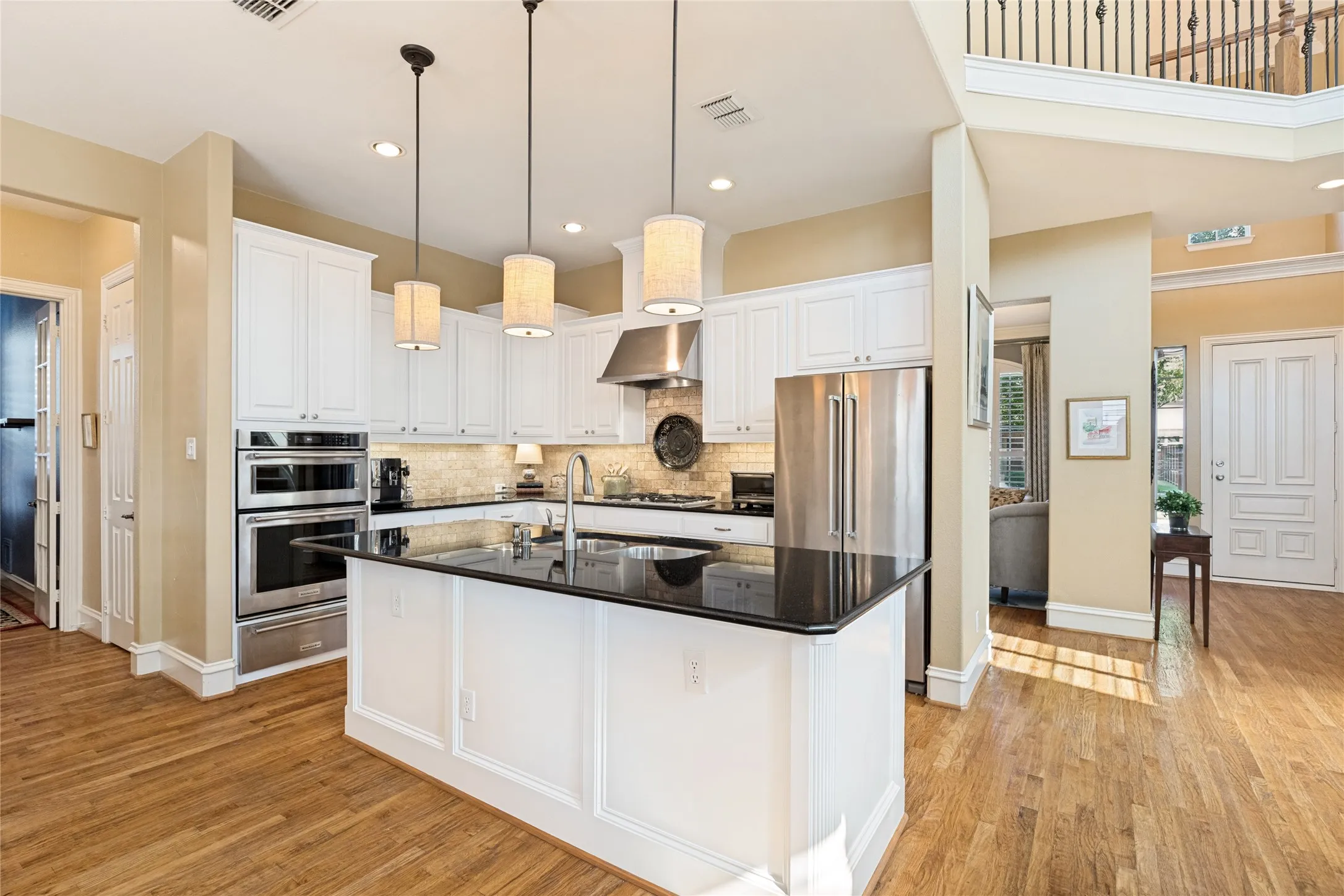 Warm under cabinet lighting in kitchen and pendant lights over island