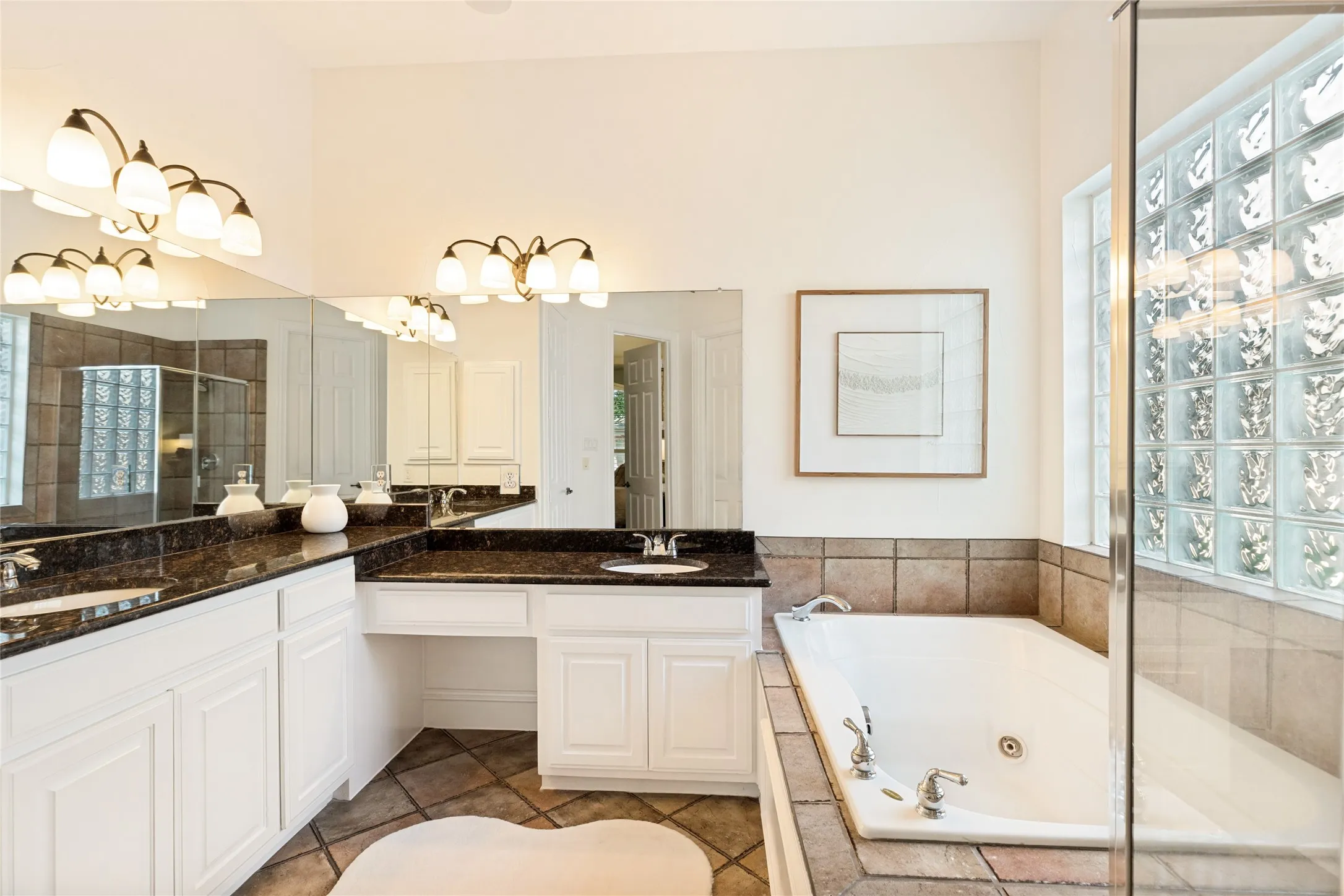Spacious primary bath with separate hi-low sinks, vanity, jetted tub, block windows for light and separate shower