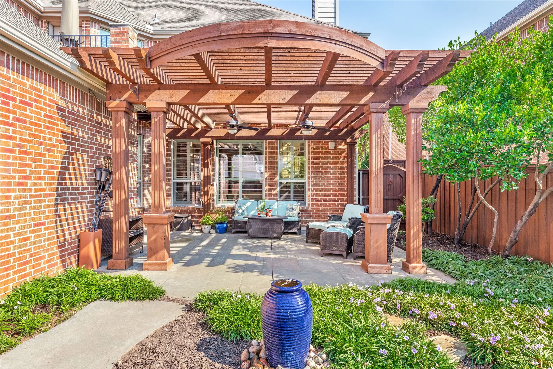 View of back patio with fountain and stepping stones to gate
