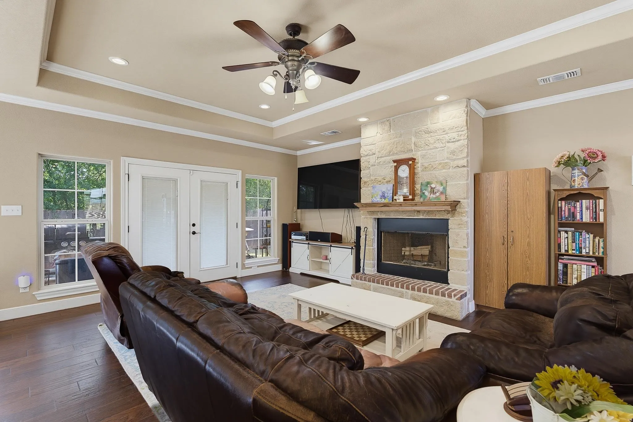 Living area featuring a stone-clad fireplace with a wood mantle and brick hearth