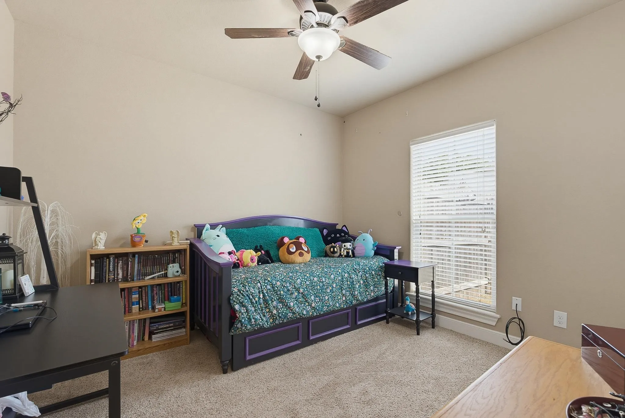 Carpeted room featuring a ceiling fan with light fixture, a single window with horizontal blinds, and neutral-toned walls