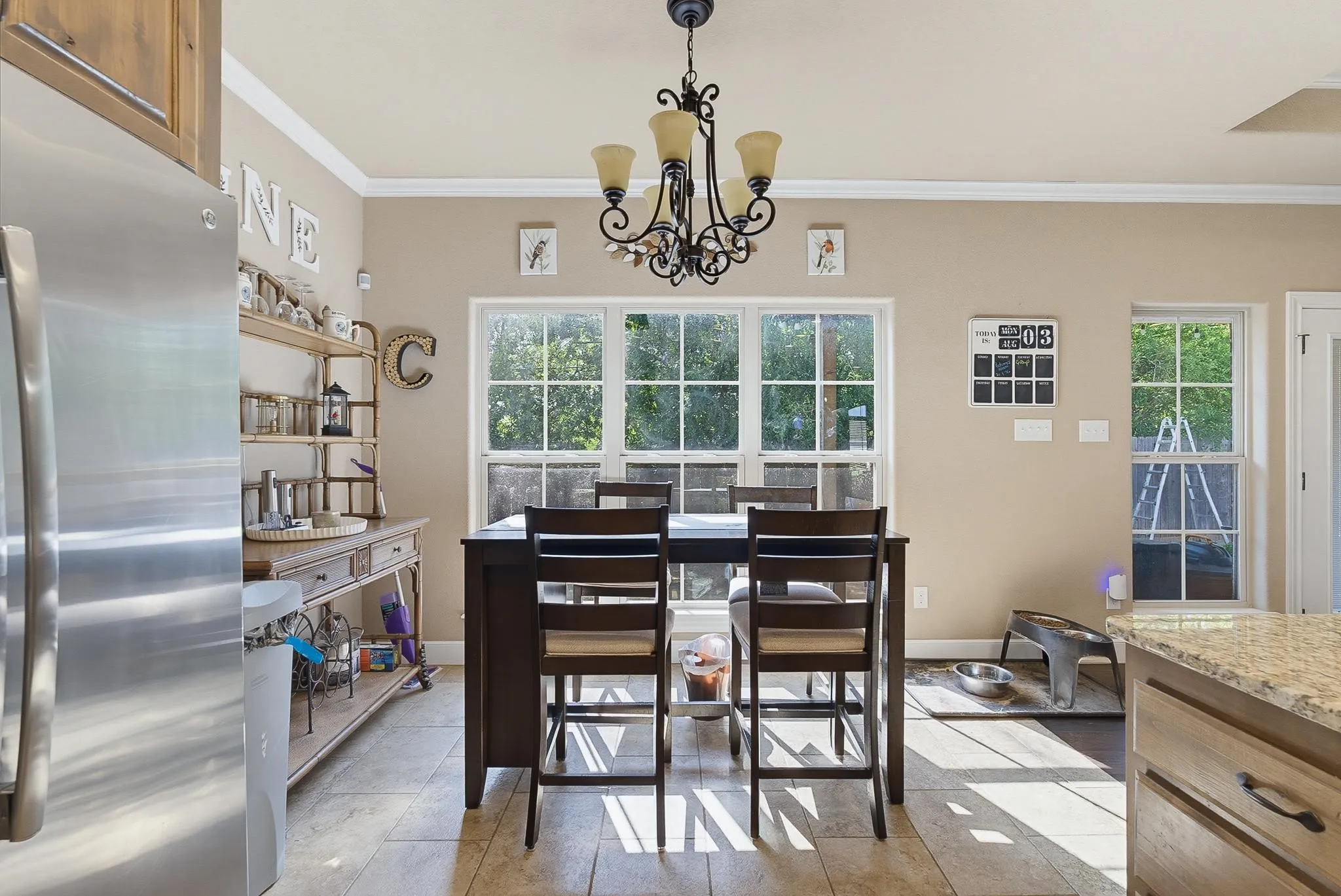 Kitchen dining area featuring ample natural light, a chandelier, tile flooring, and crown molding