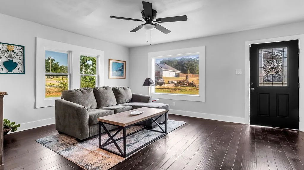 Spacious room featuring dark wood-finish flooring, light gray walls, and white trim