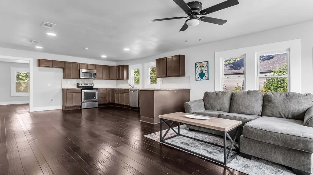 Open-concept living space featuring wood-finish flooring, recessed lighting, and a ceiling fan