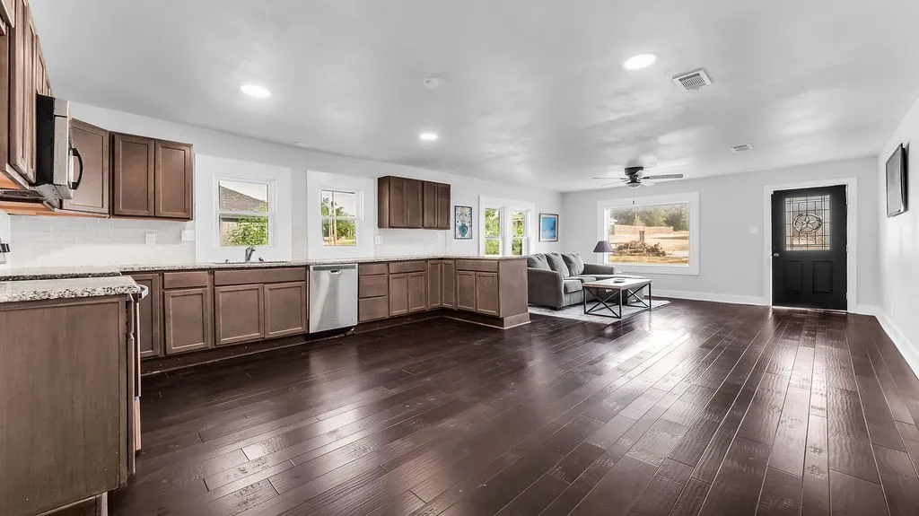 Open-concept living area featuring rich wood-finish flooring