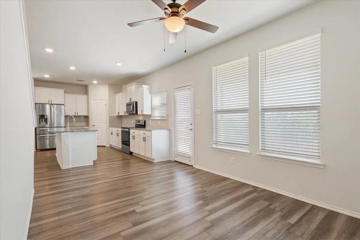 Open-concept living space featuring wood-finish flooring, recessed lighting, and a ceiling fan