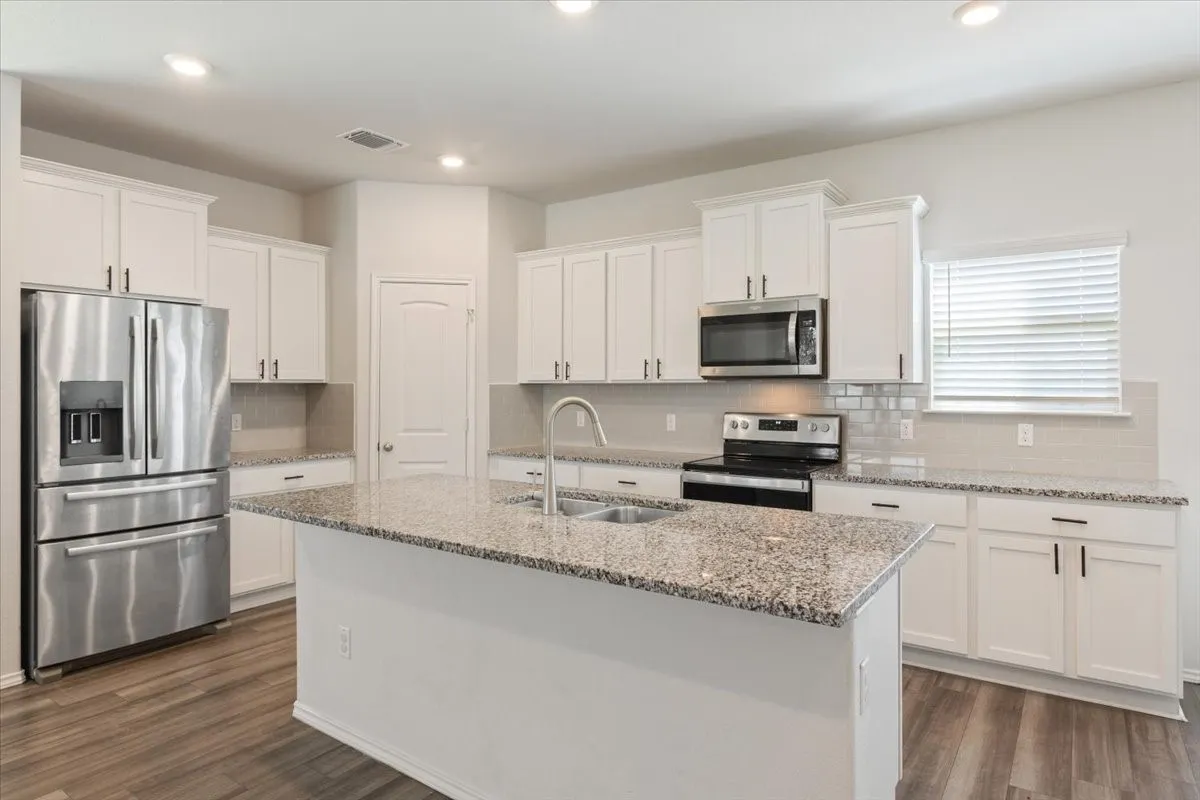 Kitchen island with stone-finish countertop and undermount sink