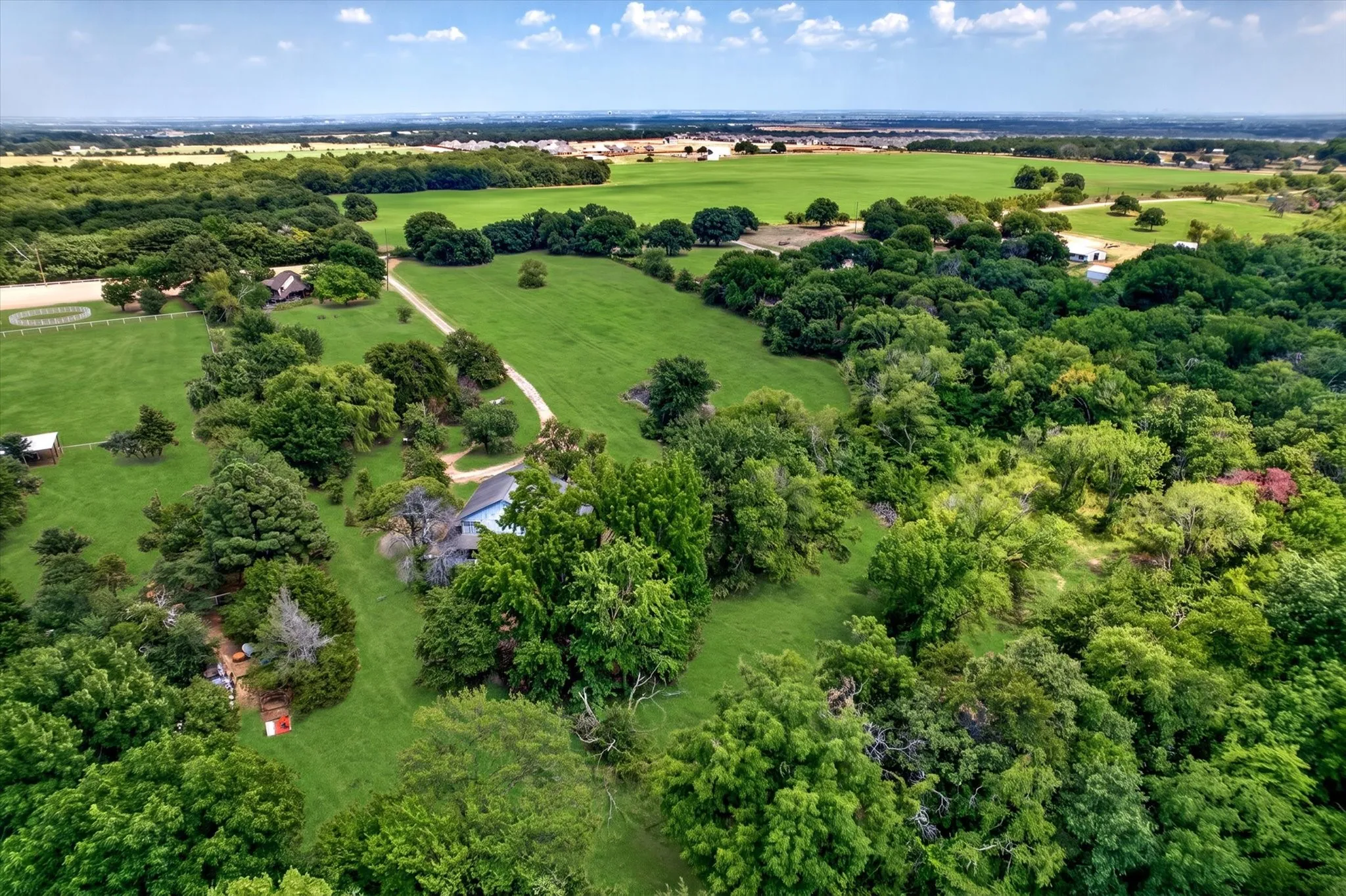 Expansive green landscape featuring mature trees and open fields
