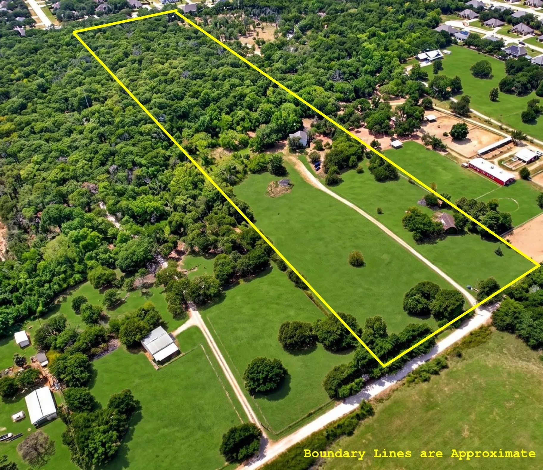 Expansive land parcel featuring a significant portion of mature trees, open grassy areas, and a visible meandering track