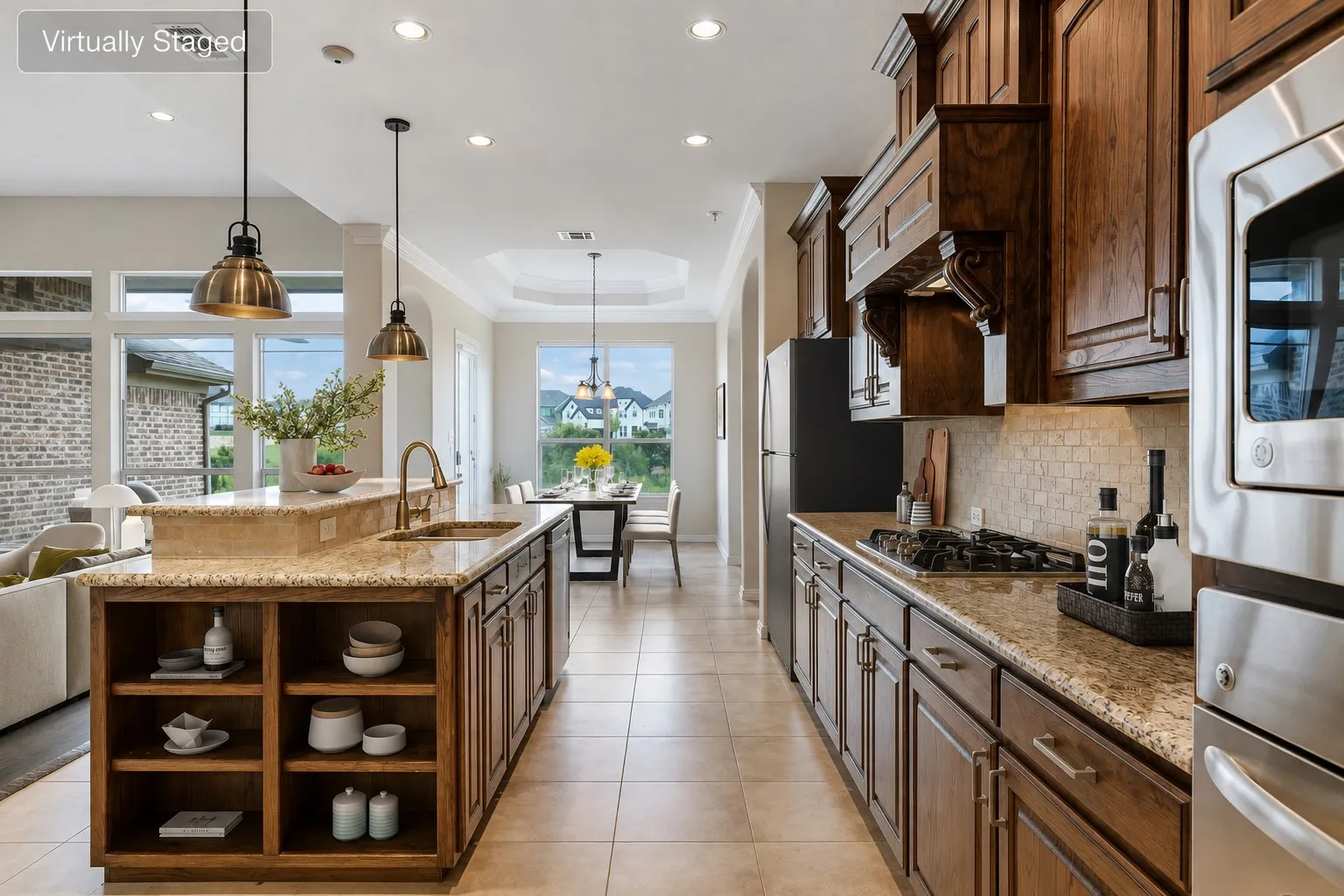 Spacious kitchen featuring a central island with a sink, pendant lighting, built-in shelving, and granite countertops