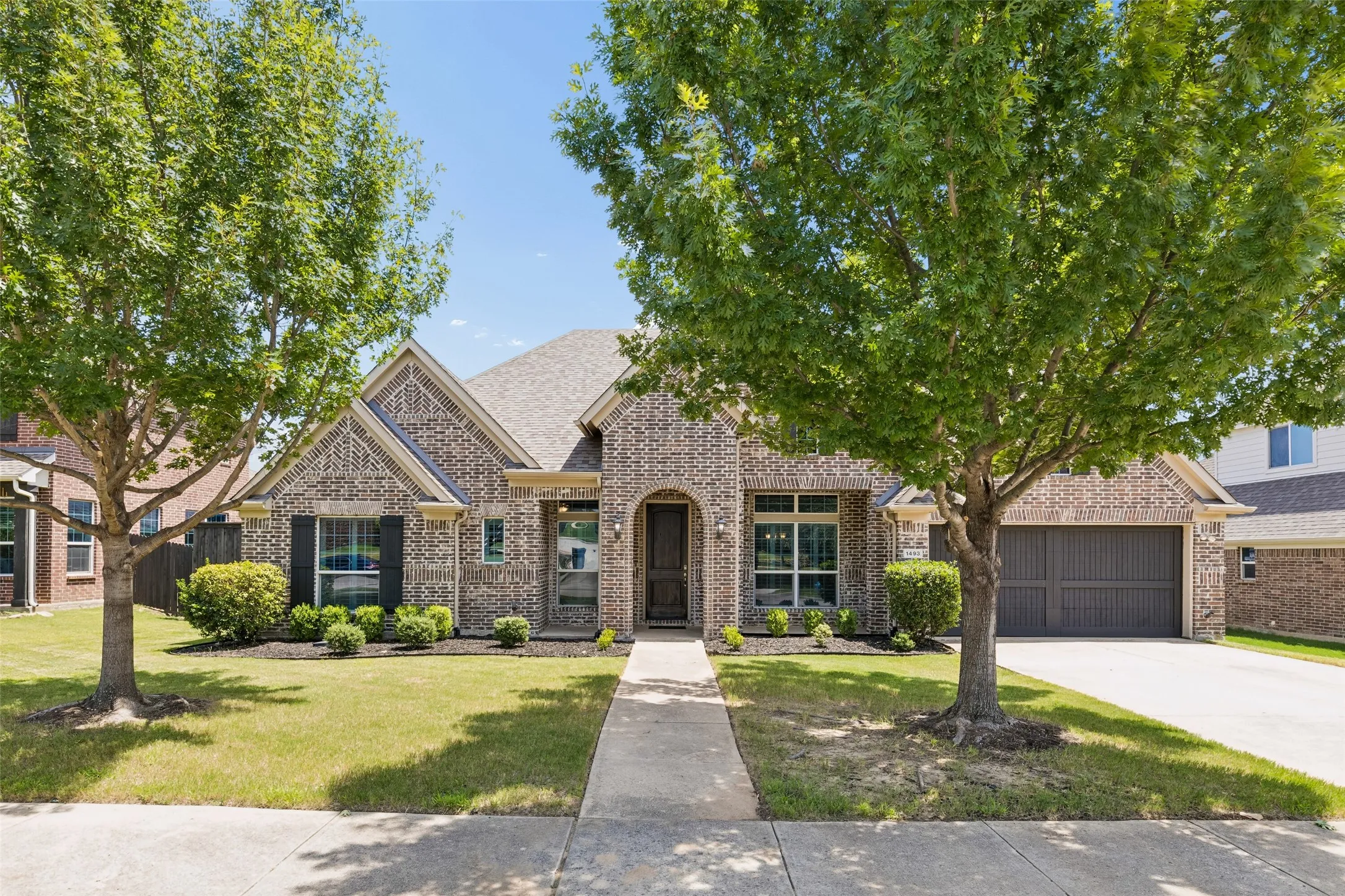 Traditional brick facade with architectural gables and an attached two-car garage