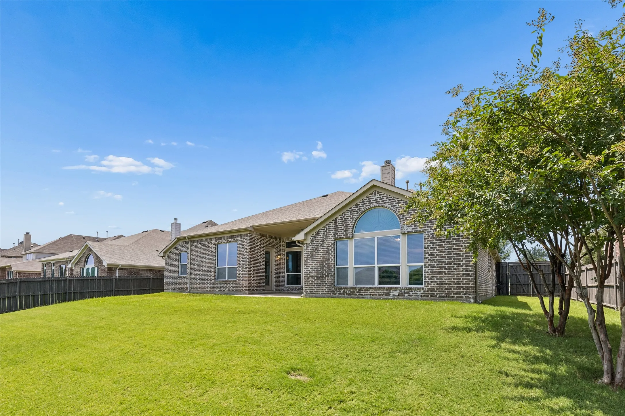 Expansive green lawn with a privacy fence