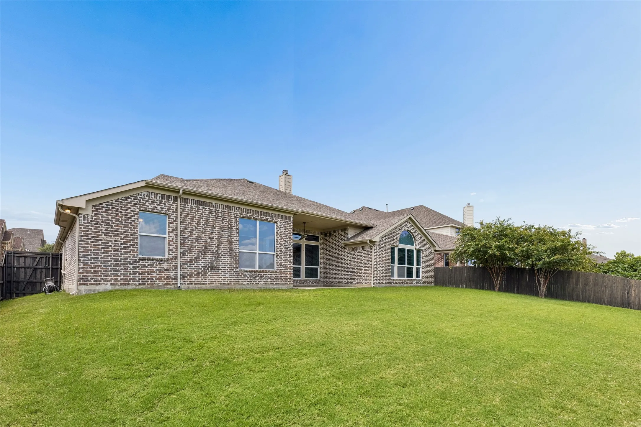 Expansive green lawn bordering the rear elevation