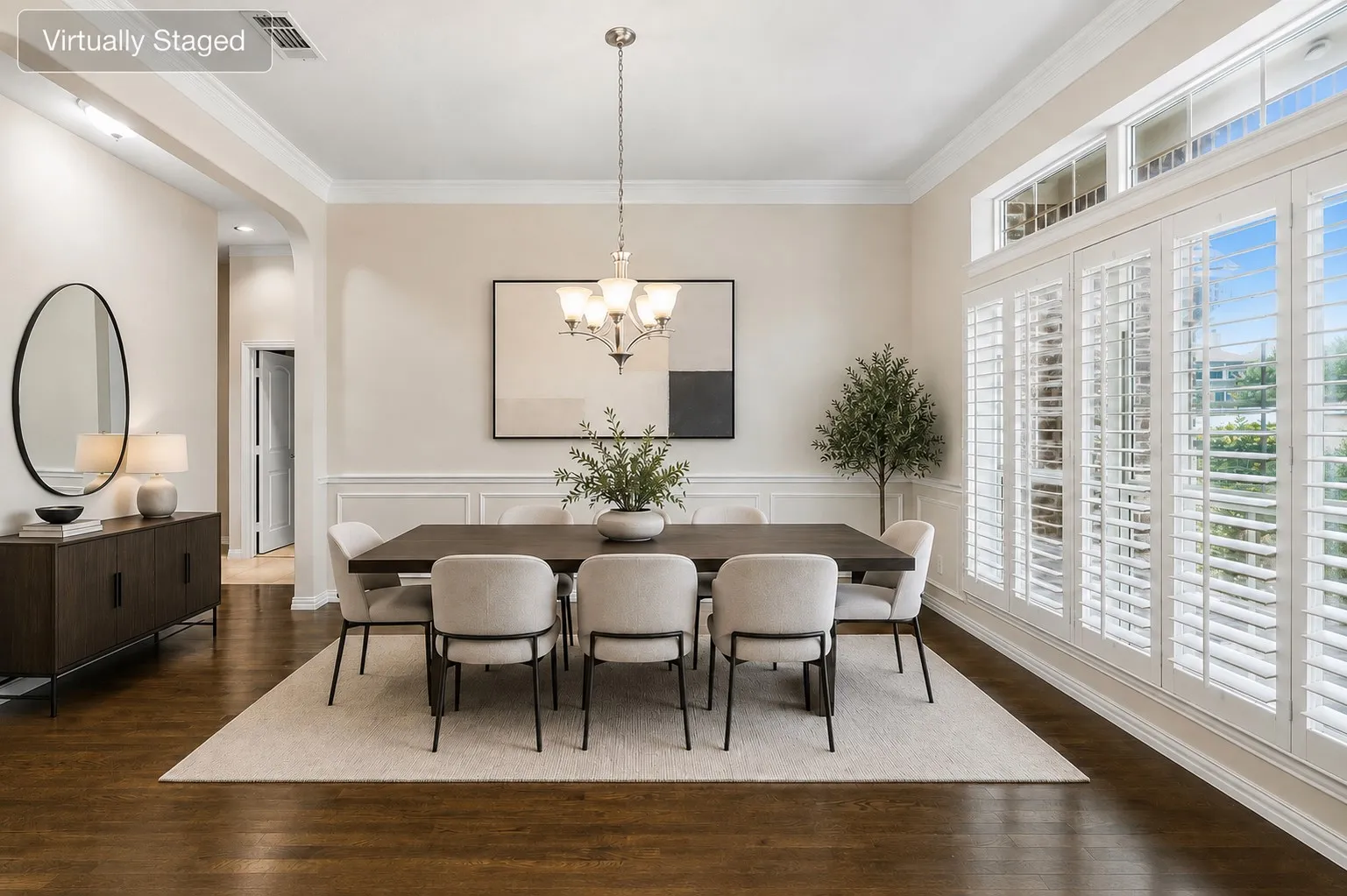 Dining area featuring rich wood-finish flooring, wainscoting, and crown molding