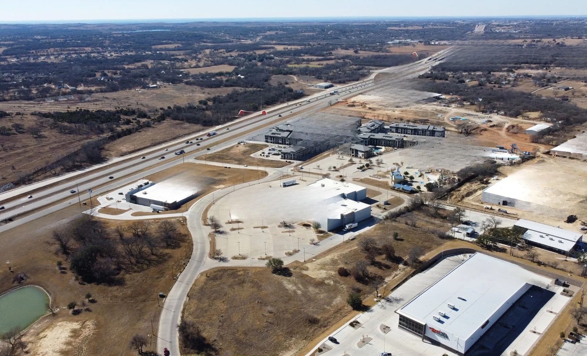 Aerial perspective showcasing extensive commercial properties alongside a multi-lane highway