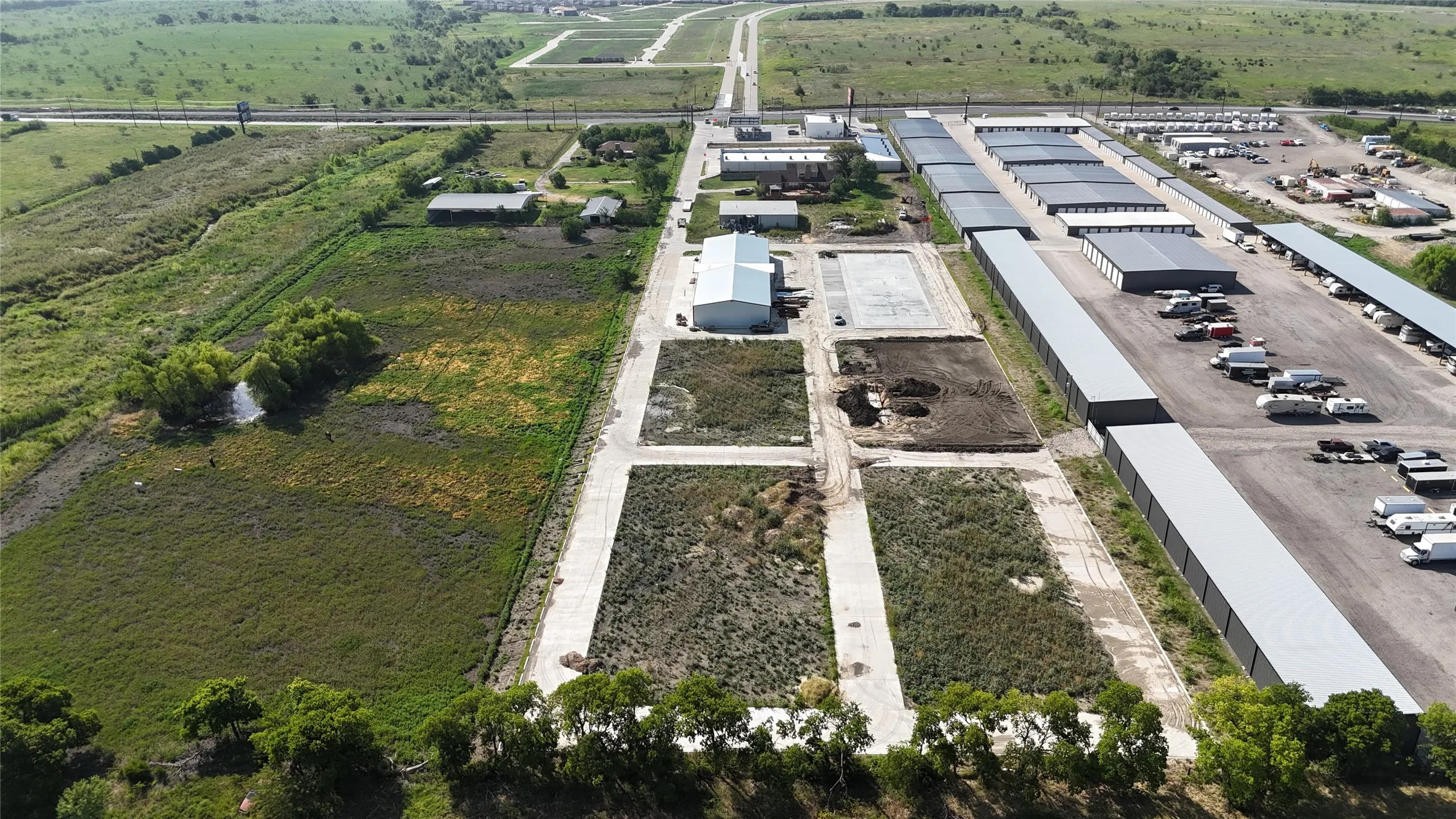 Expansive commercial property featuring undeveloped land parcels and existing structures