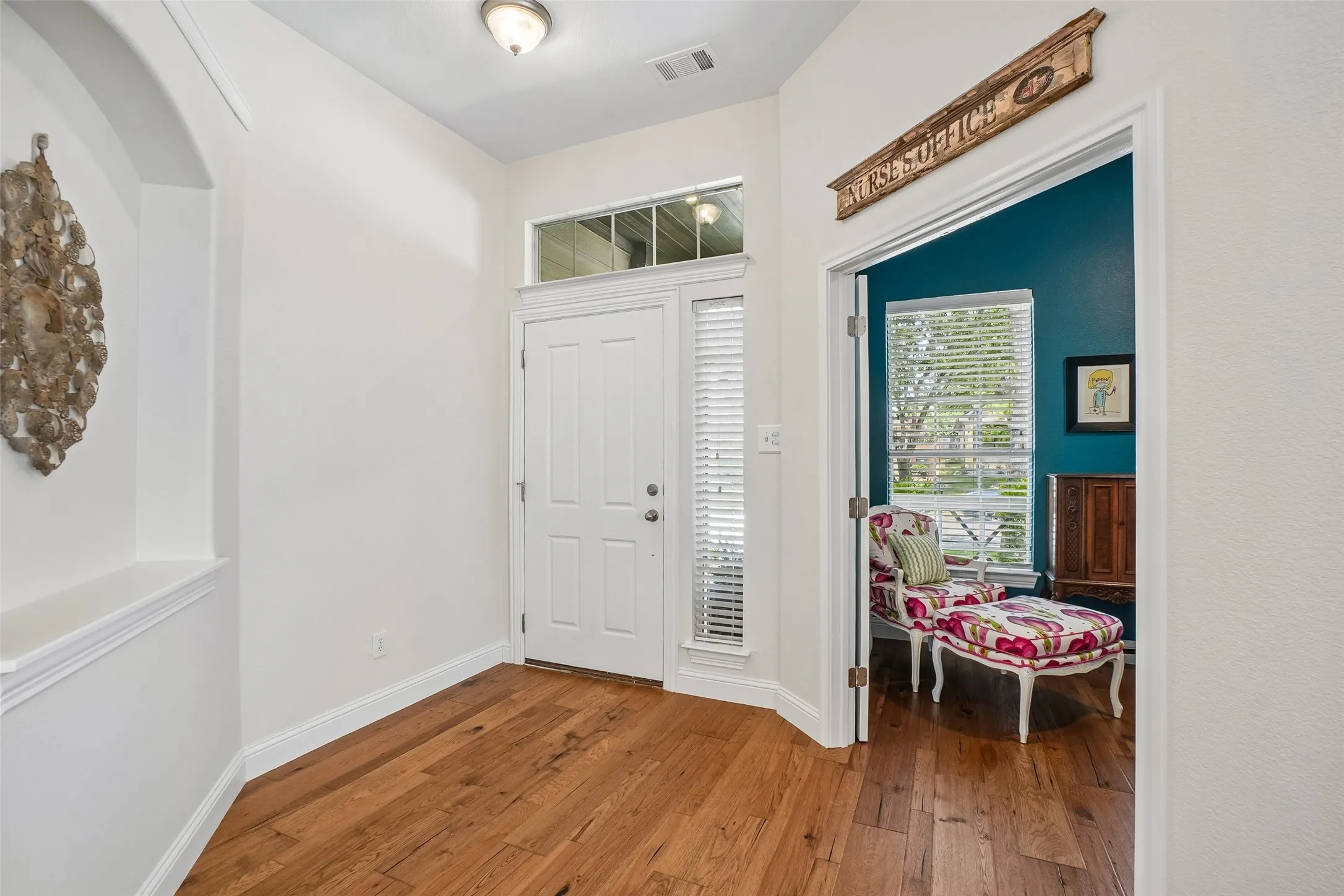Entry with engineered hickory wood floors and doors that open to an office. Art niche on the left.