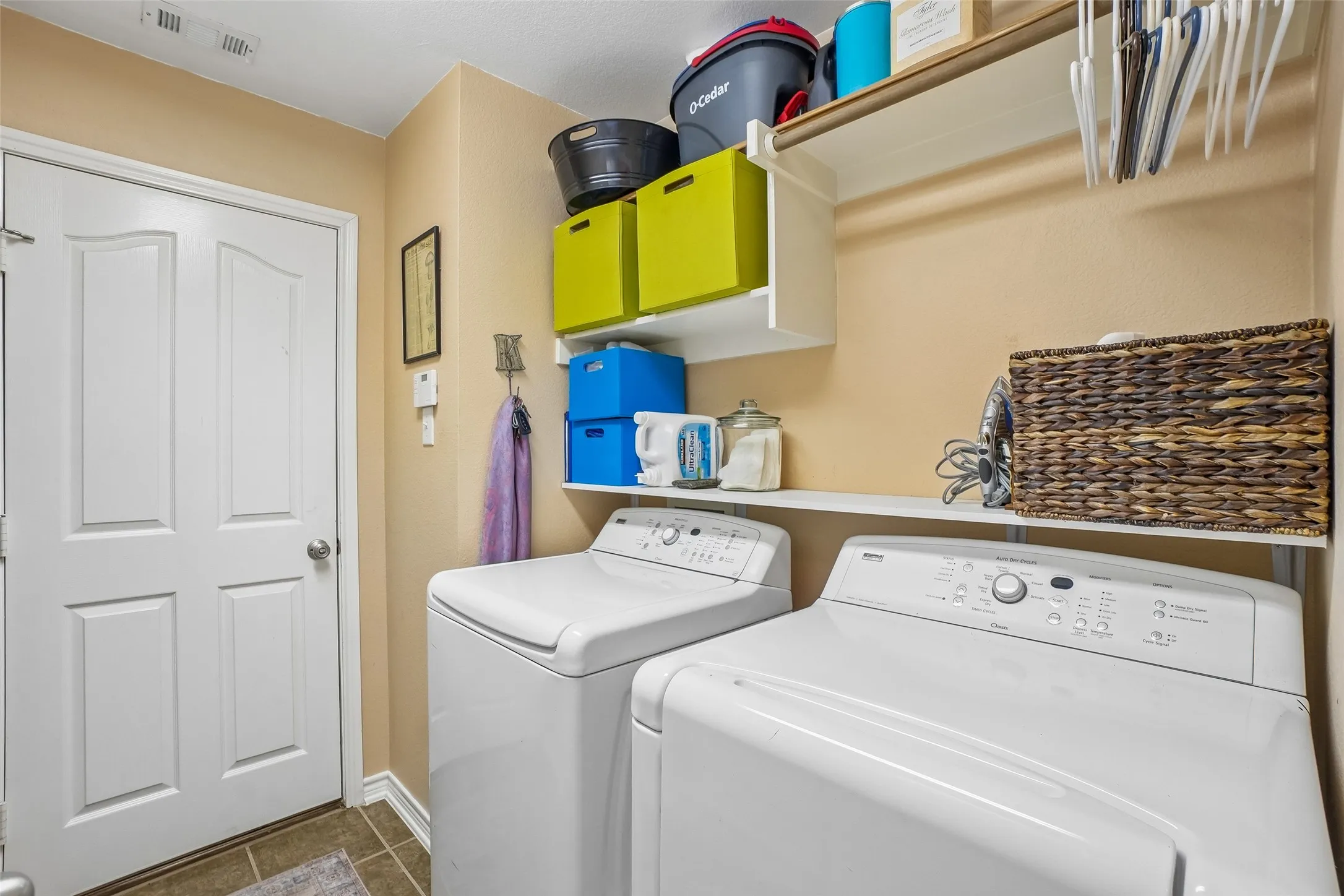 Tile floor. Shelves for storage and a rack for hanging clothes.