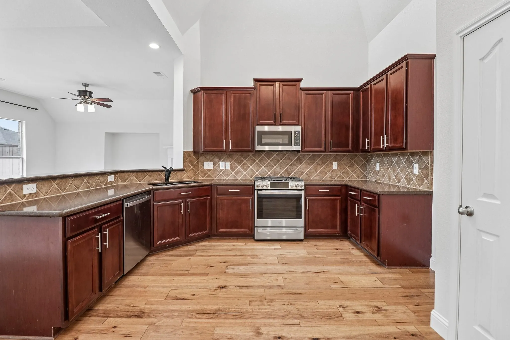 Kitchen with new flooring and updated stainless steel appliances.