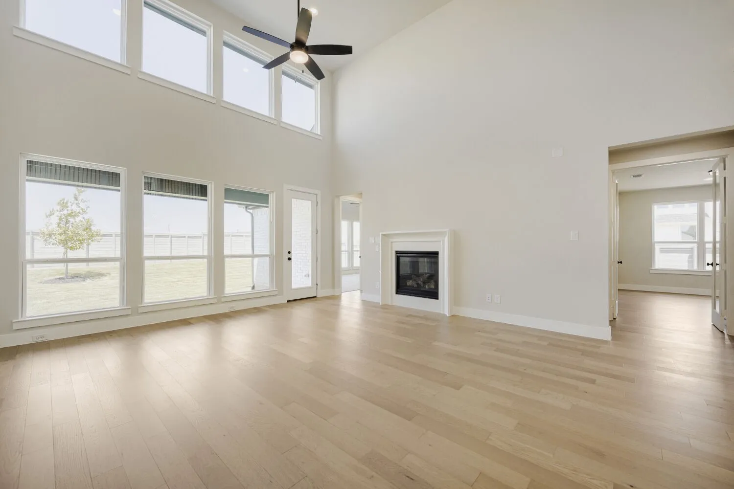 Spacious living area featuring a vaulted ceiling and light wood-finish flooring