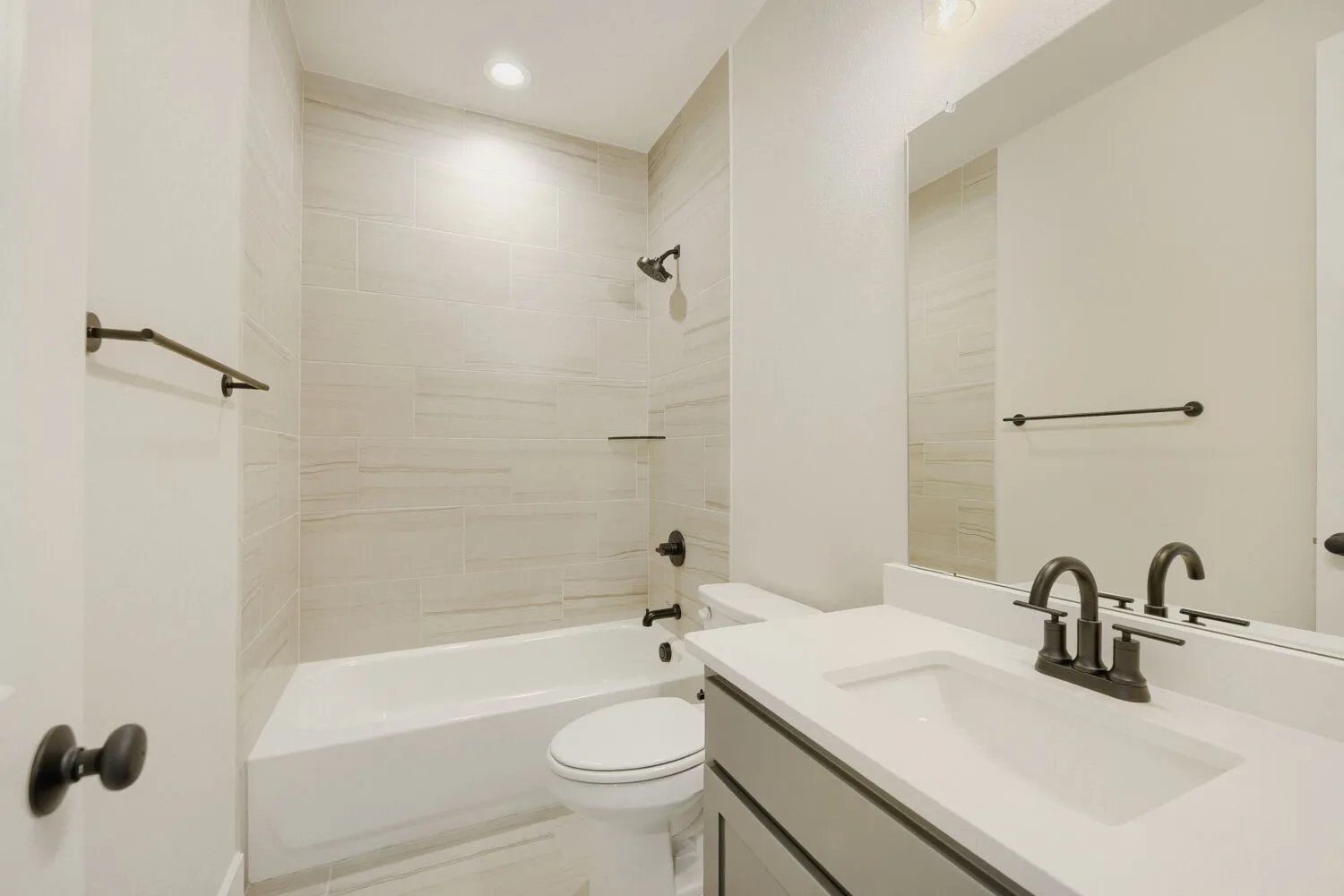 Bathroom featuring a single vanity with a white countertop, an undermount sink, and dark bronze fixtures