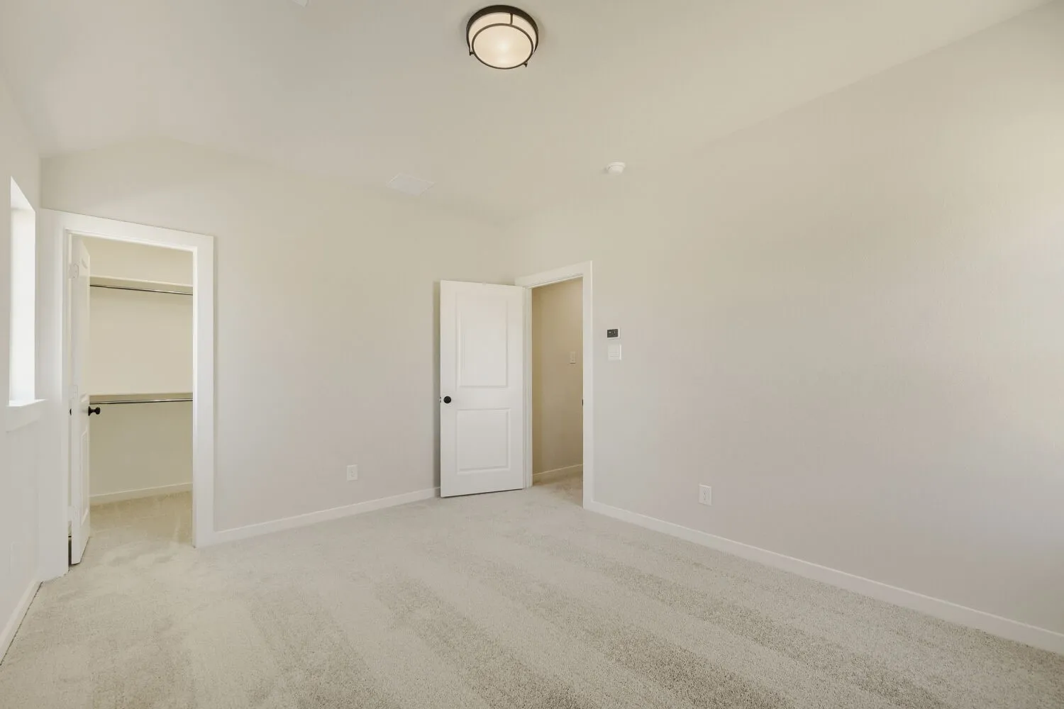 Carpeted room featuring a window, overhead lighting, a closet, and white interior doors