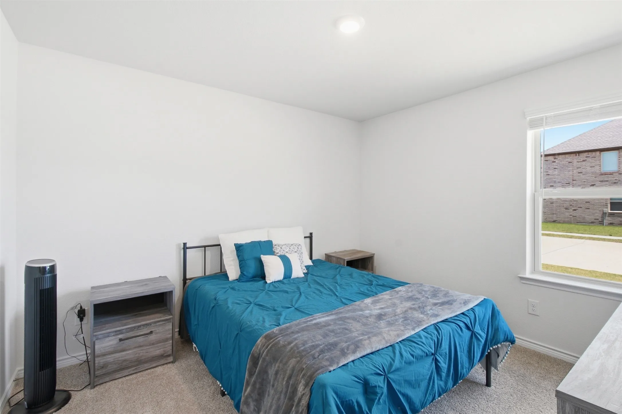 Bright bedroom featuring a recessed light, soft carpet flooring, and a window with blinds