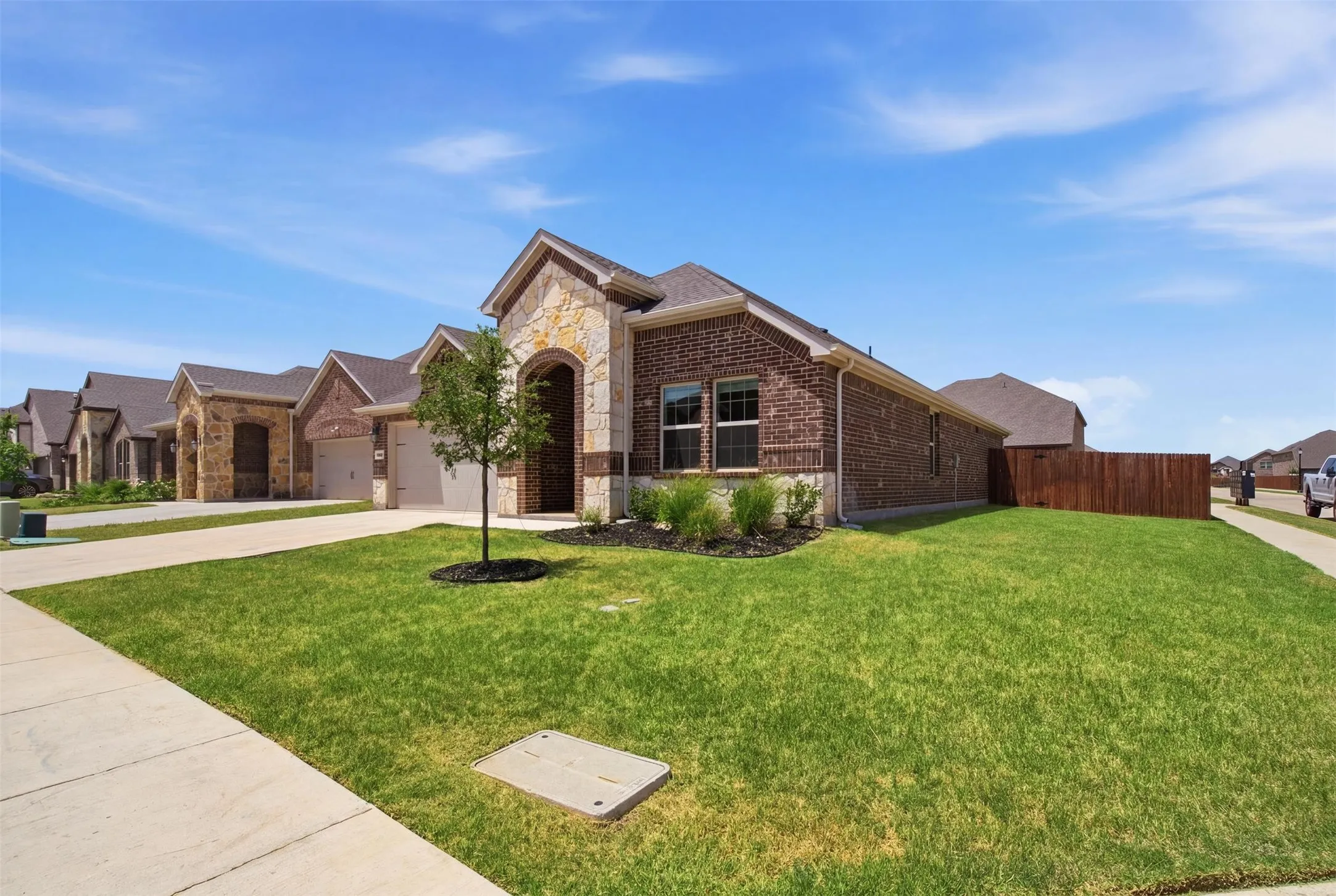Single-story residence featuring brick and stone veneer siding with a prominent arched entry