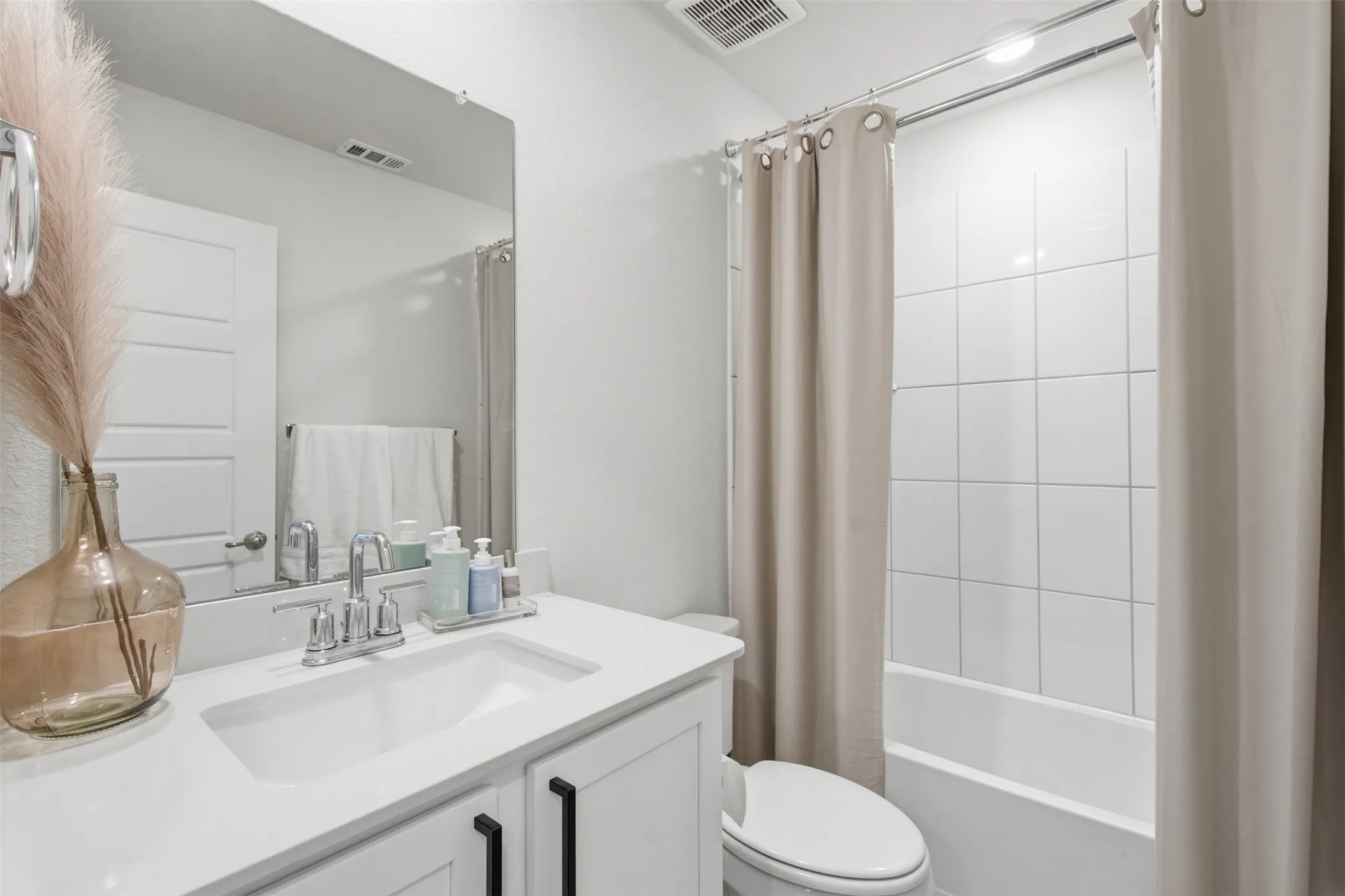 Bathroom vanity with white countertop, undermount sink, and chrome faucet