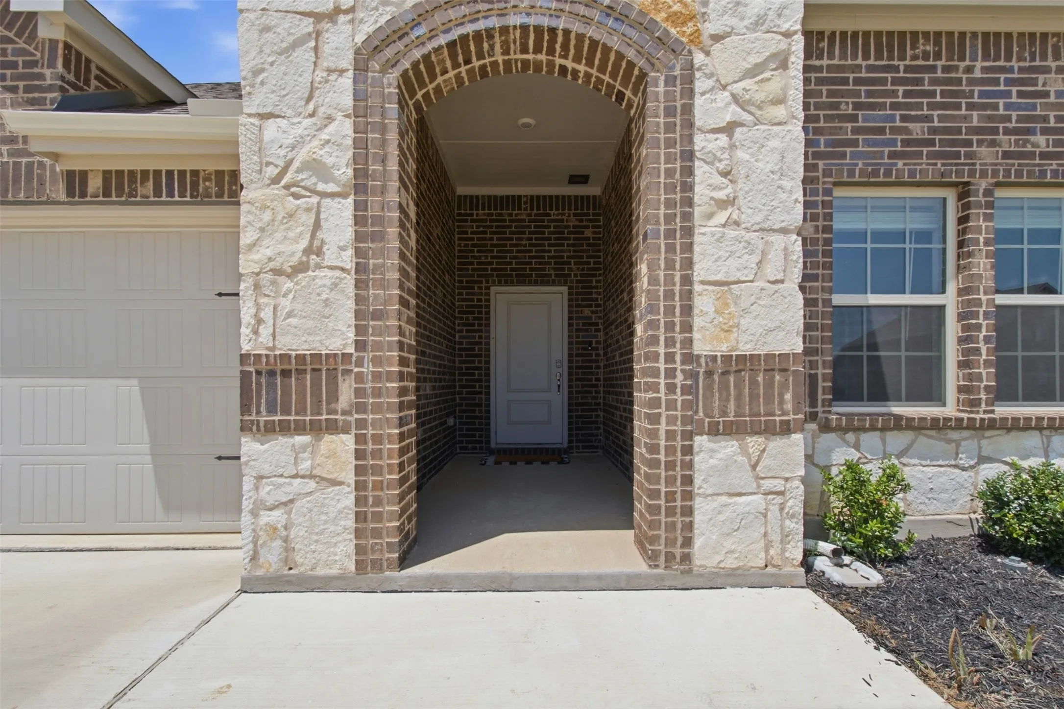 Arched entryway featuring a combination of brick and natural stone masonry