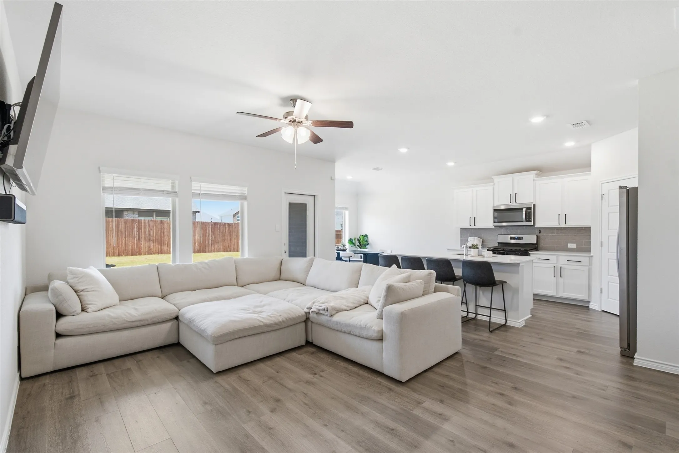 Open-concept living space featuring wood-finish flooring, recessed lighting, and a ceiling fan