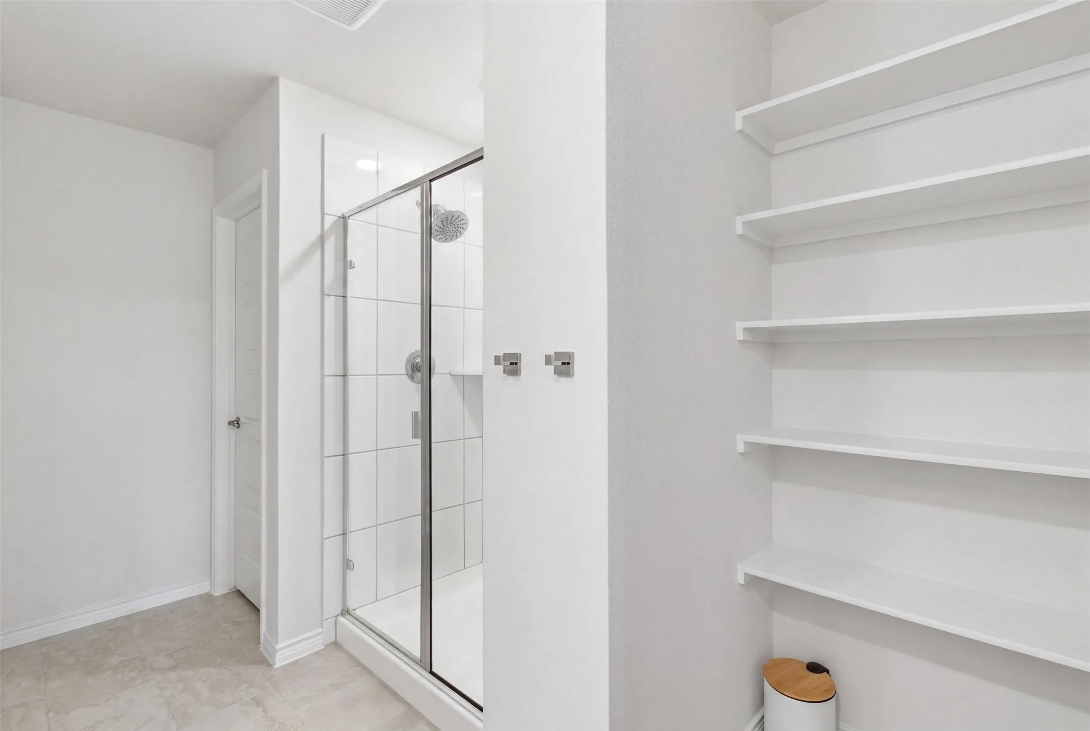Walk-in shower with clear glass enclosure and subway tile surround, complemented by a rainfall showerhead