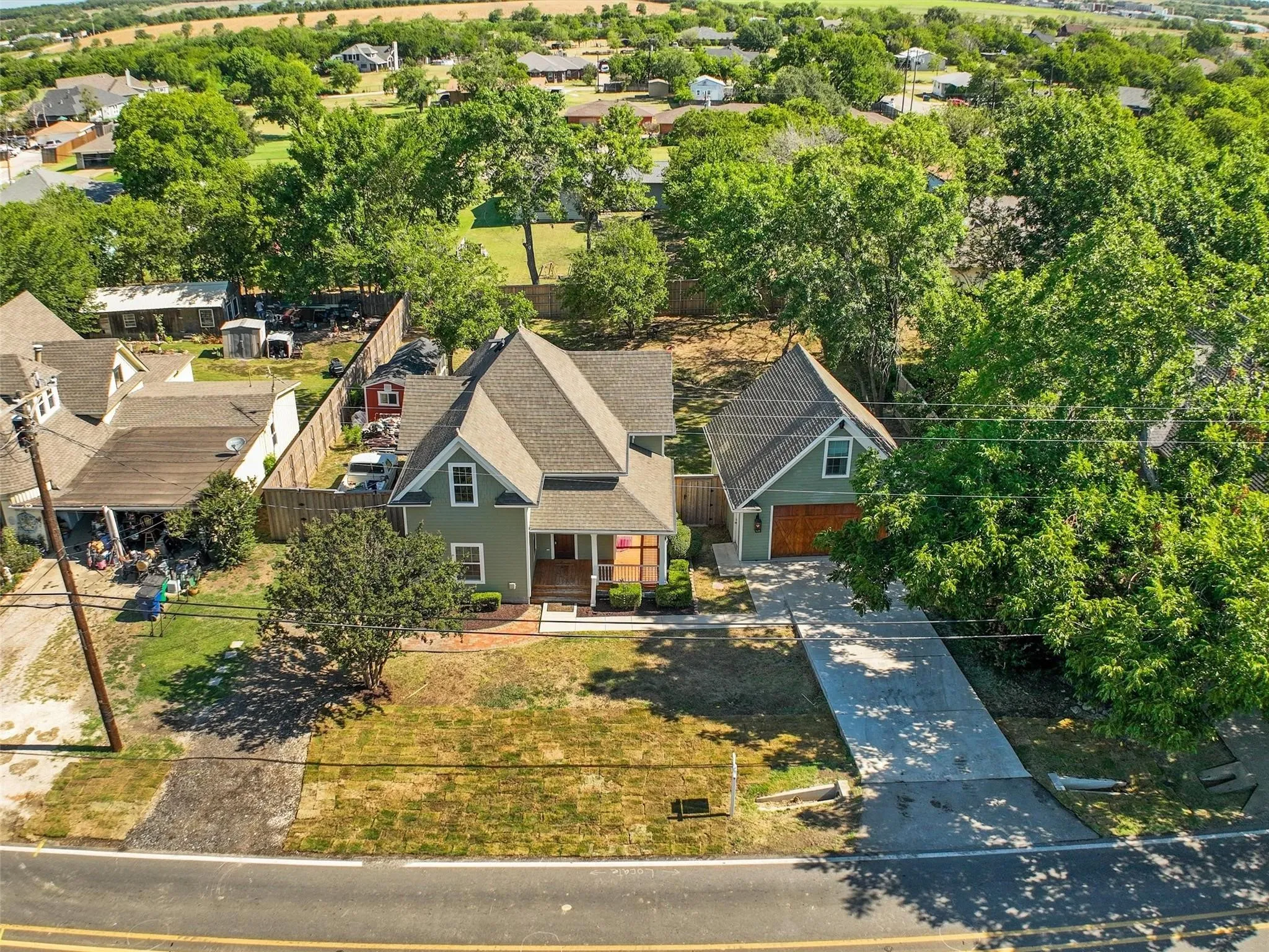 Charming residential property featuring a green exterior, gabled rooflines, and a covered front porch