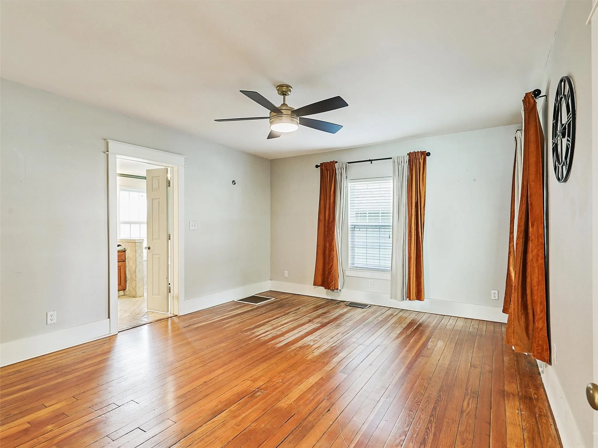 Hardwood flooring, white walls, and a ceiling fan with integrated lighting