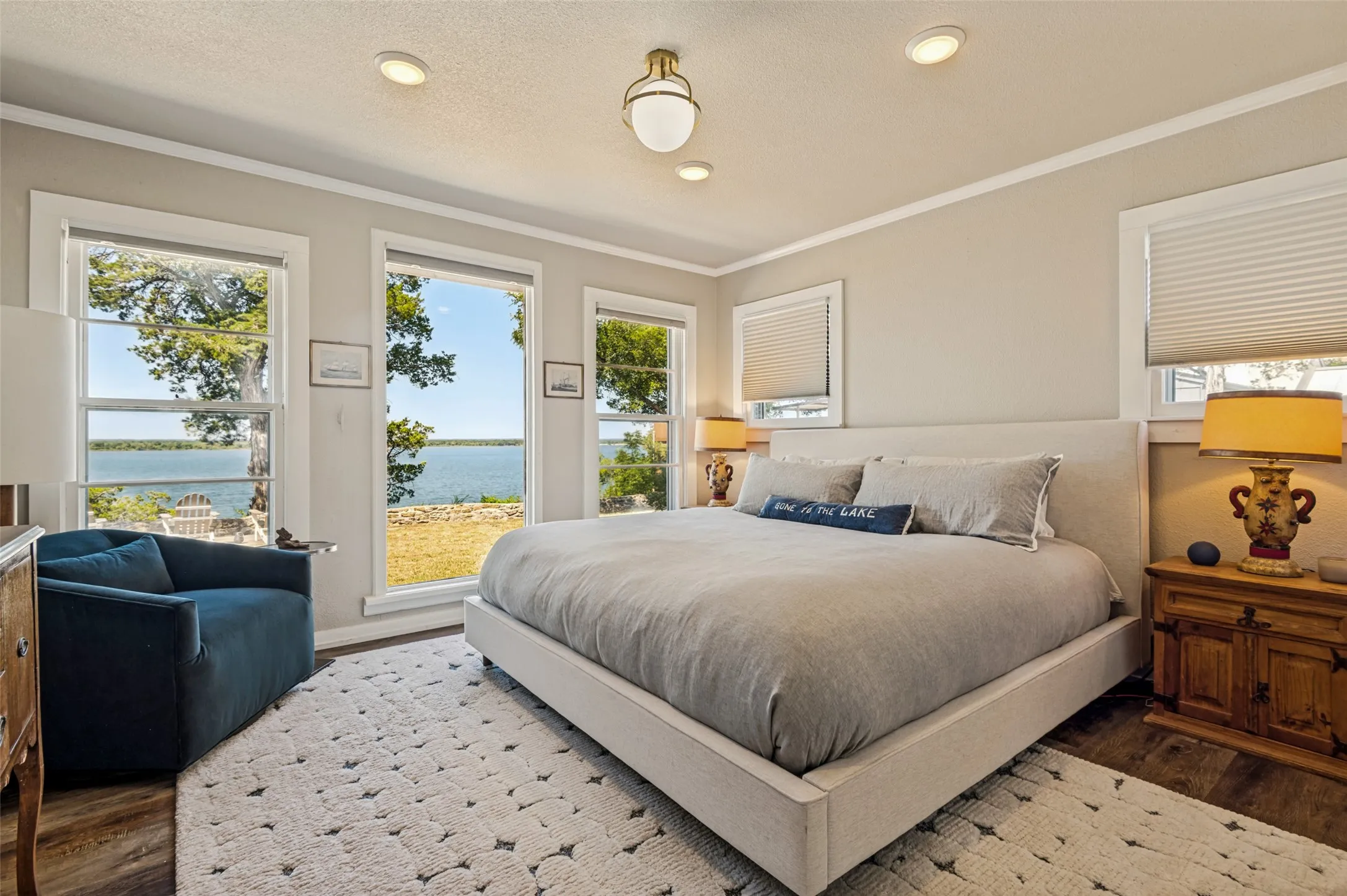 Primary bedroom with large windows overlooking lake.