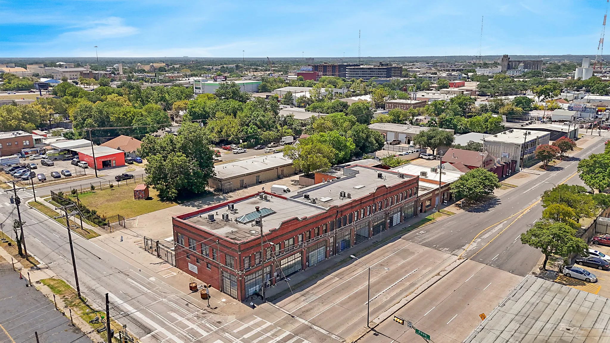 Brick commercial building featuring multiple storefronts, a flat roof, and an urban setting