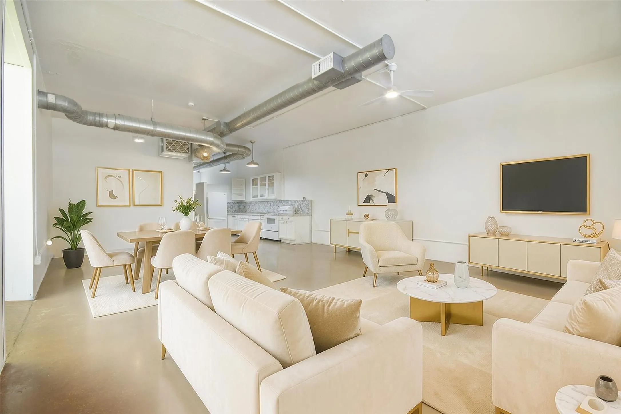 Expansive open-concept living space featuring high ceilings, exposed industrial ductwork, and polished concrete flooring